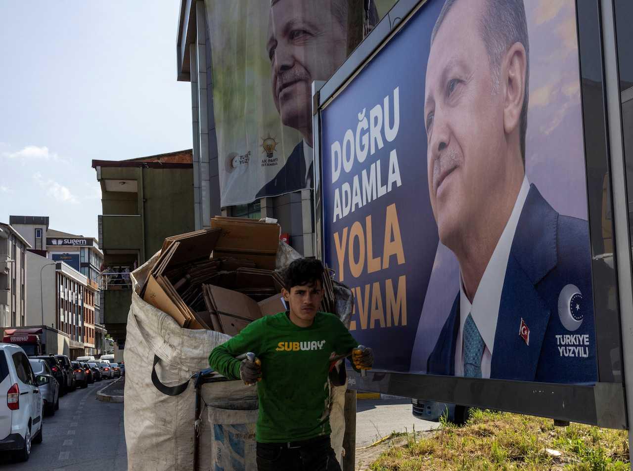 Seorang lelaki berjalan bersebelahan poster Presiden Turkiye Tayyip Erdogan, menjelang pusingan penentuan pilihan raya presiden pada 28 Mei, di Istanbul, 22 Mei. Gambar: Reuters