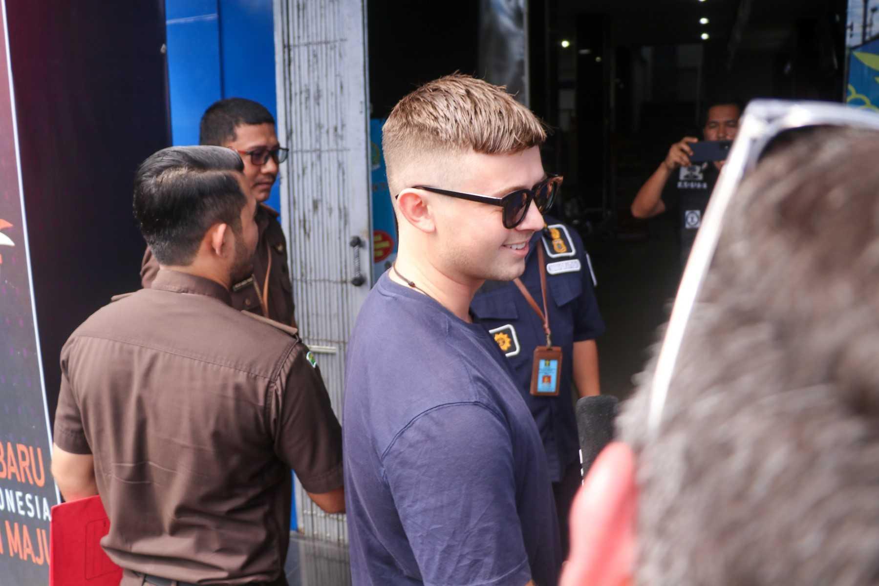 Australian surfer Bodhi Mani Risby-Jones smiles as he is handed over to immigration after being released from prison in Meulaboh on June 7. Photo: AFP 