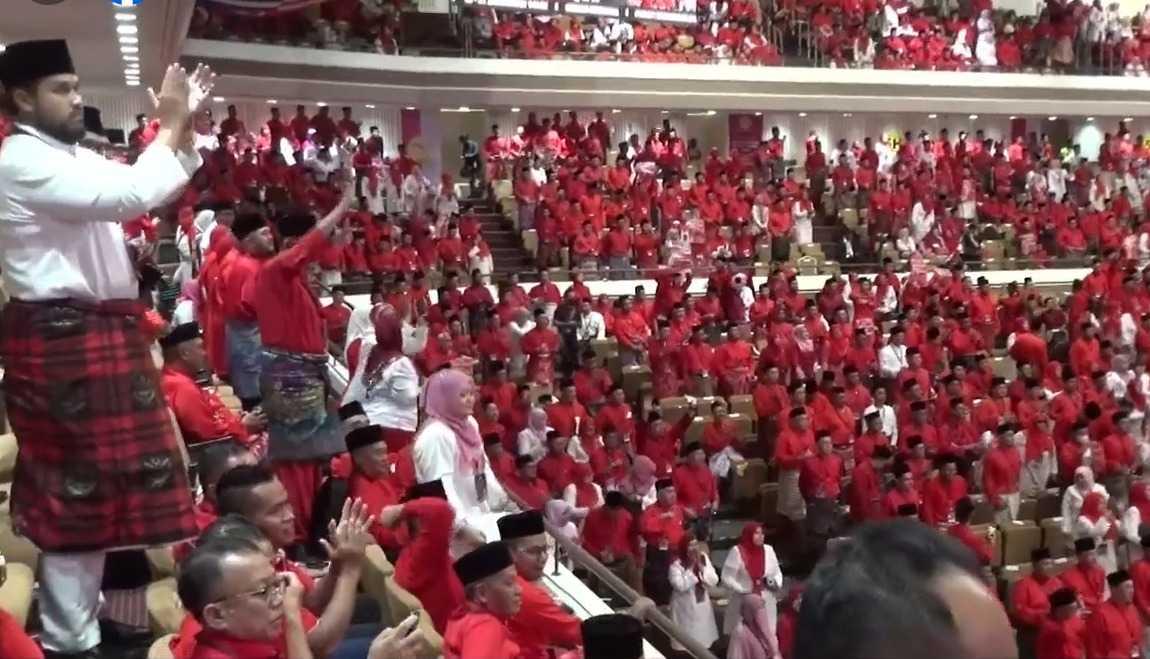 Delegates erupt in applause as Umno president Ahmad Zahid Hamidi calls for Najib Razak's freedom at the Merdeka Hall, where Prime Minister Anwar Ibrahim and other top Pakatan Harapan leaders also attended the party's general assembly.