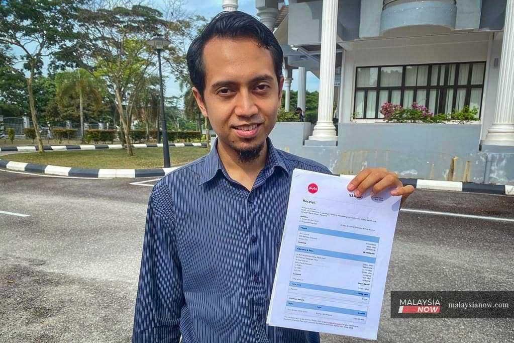 Aiman Md Uslim menunjukkan resit tempahan tiket penerbangan AirAsia X yang dibeli pada 3 November 2019 berjumlah RM4,149 ketika ditemui MalaysiaNow di perkarangan Kompleks Mahkamah Sepang.