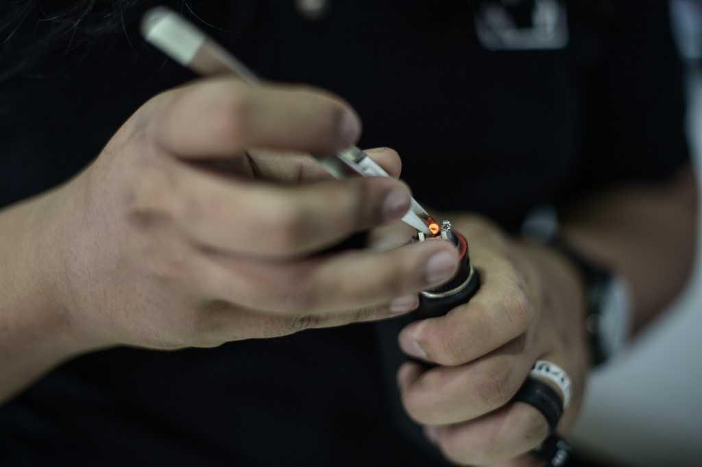 A worker inspects the metal heating element in an e-cigarette that produces vapour from e-juices, at a vape shop in Kuala Lumpur. Photo: AFP
