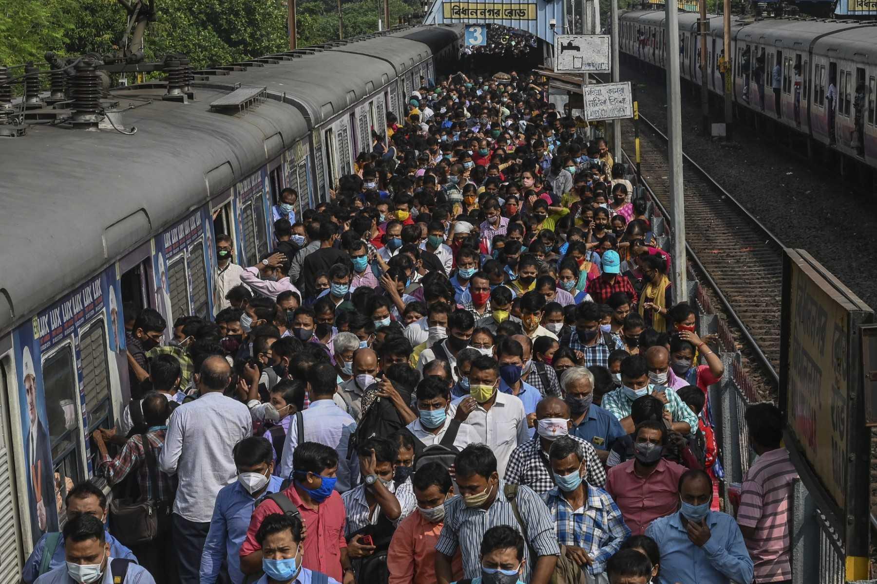 Commuters walk along a railway platform after stepping out from a suburban local train in Kolkata on Nov 1, 2021. Photo: AFP  