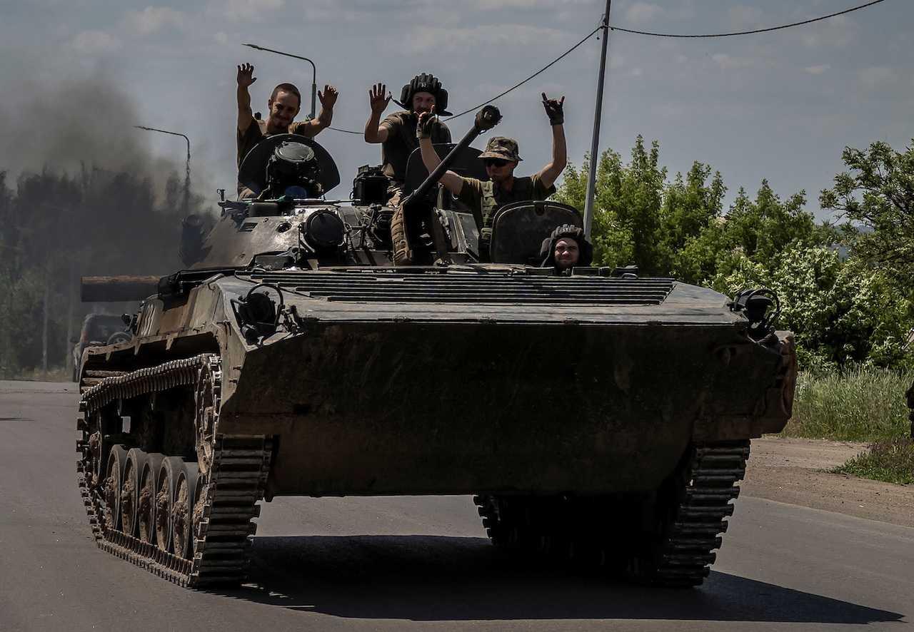 Ukrainian service members ride a BMP-1 infantry fighting vehicle, amid Russia's attack, near the front line city of Bakhmut, Donetsk region, Ukraine, June 9. Photo: Reuters