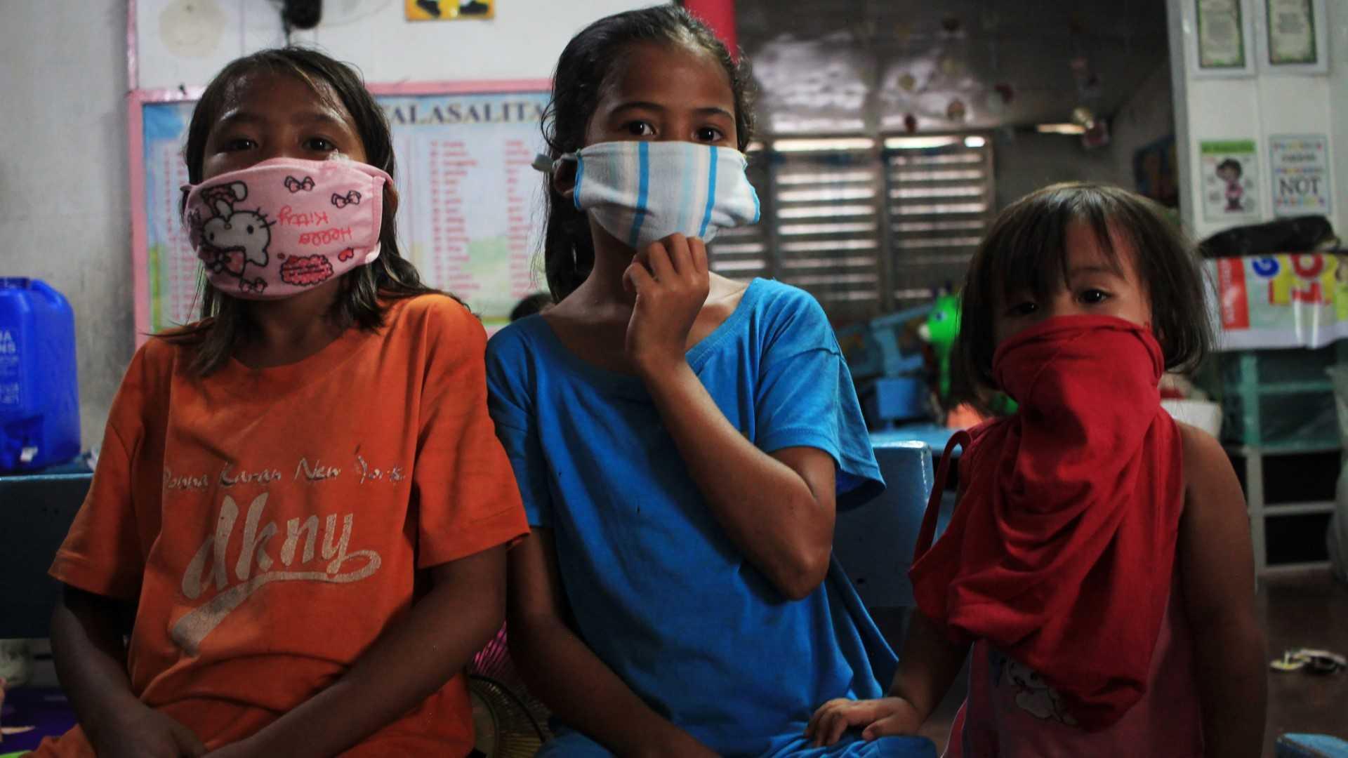 Children wearing improvised face masks take shelter at a school building serving as an evacuation centre in Sorsogon town, Bicol region, south of Manila on May 14, 2020. Photo: AFP  