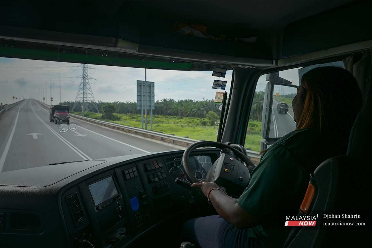 Sitting behind the wheel, far above the road, Kahmani drives from Banting to Northport in Port Klang, Selangor.