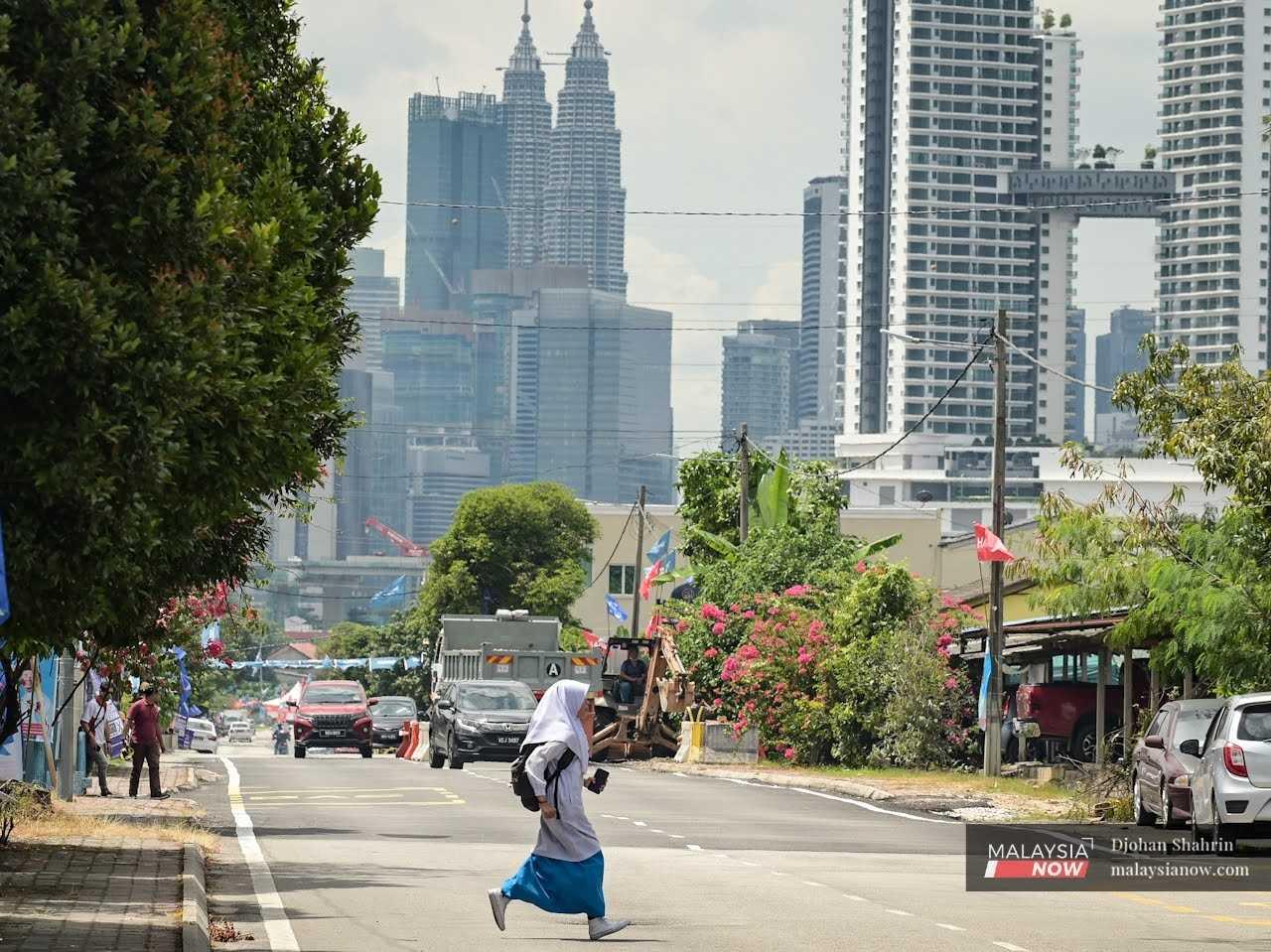 Seorang pelajar melintas jalan ketika dalam perjalanan ke sekolah di Kuala Lumpur.