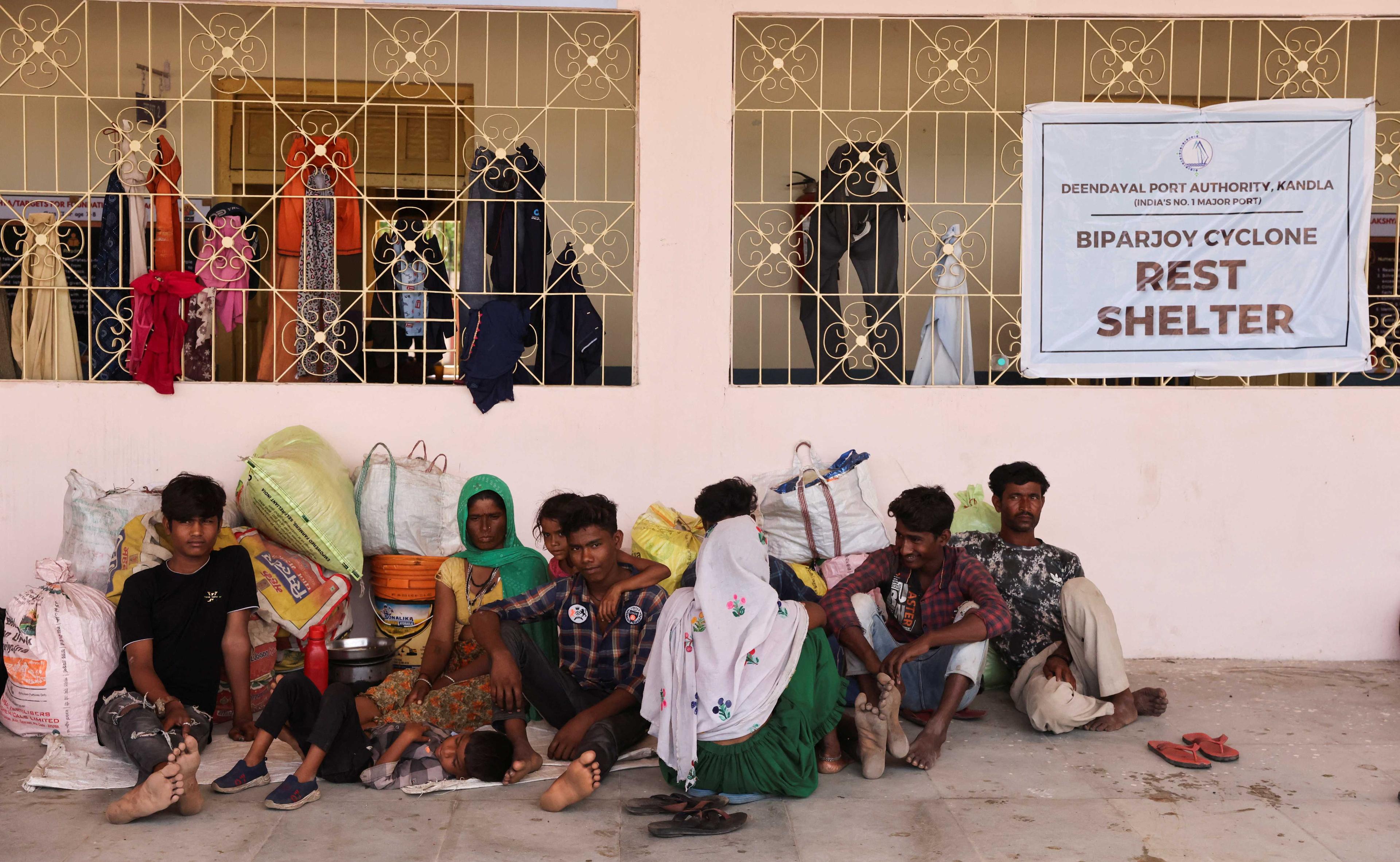 People evacuated from Kandla port sit outside a school converted into a shelter, before the arrival of cyclone Biparjoy, in Gandhidham, in the western state of Gujarat, India June 13.  Photo: Reuters
