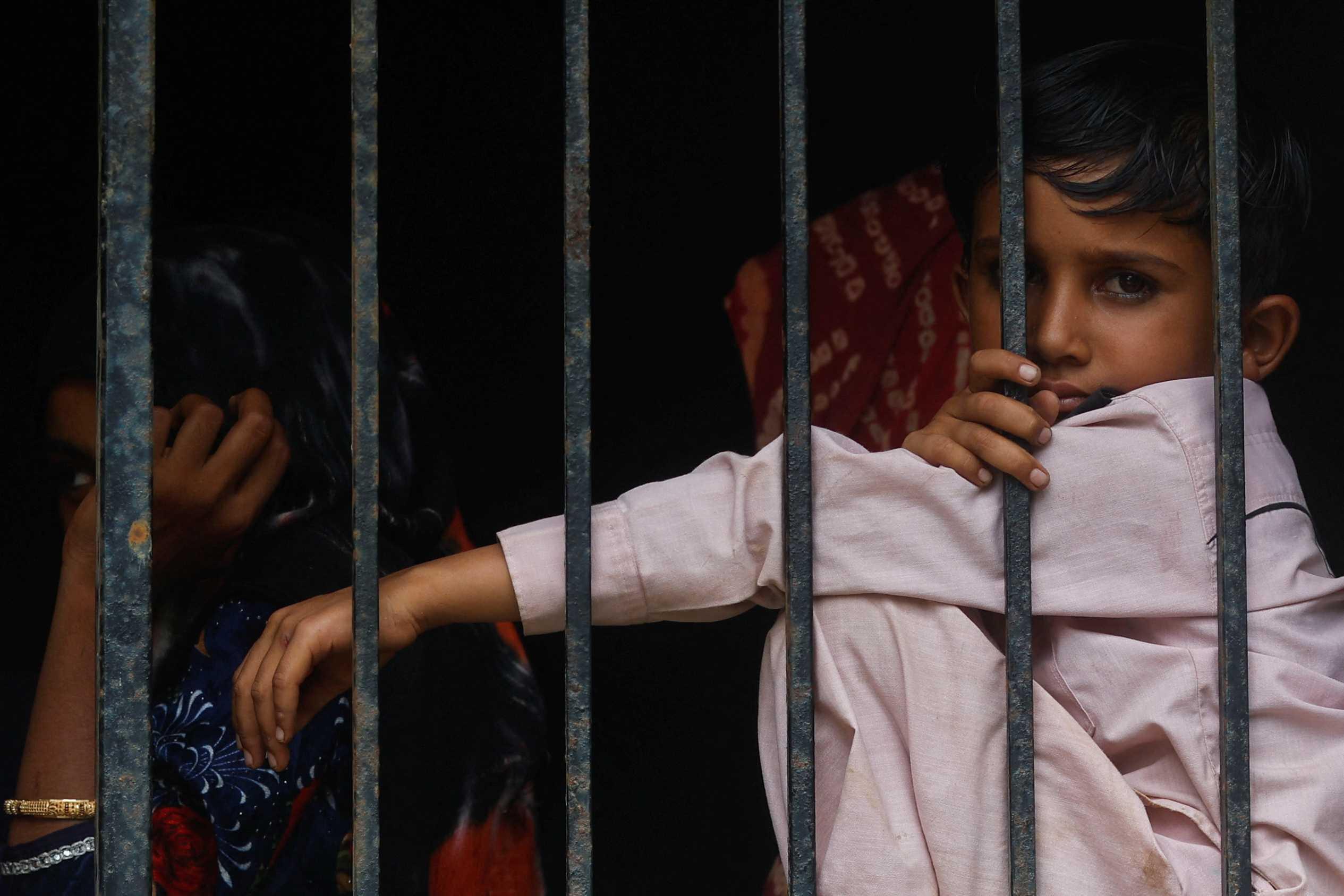 Children look out of a window of a shelter after they were evacuated from their homes in Naliya, in the western state of Gujarat, India, June 14. Photo: Reuters