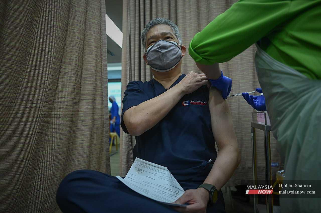 Pakar Bedah Am, Dr Khoo Kay Tim menerima vaksin Pfizer Bio-NTech dos ke tiga atau dos penggalak di Pusat Pemberian Vaksin KPJ Tawakkal, Jalan Pahang pada 25 Oktober 2021.