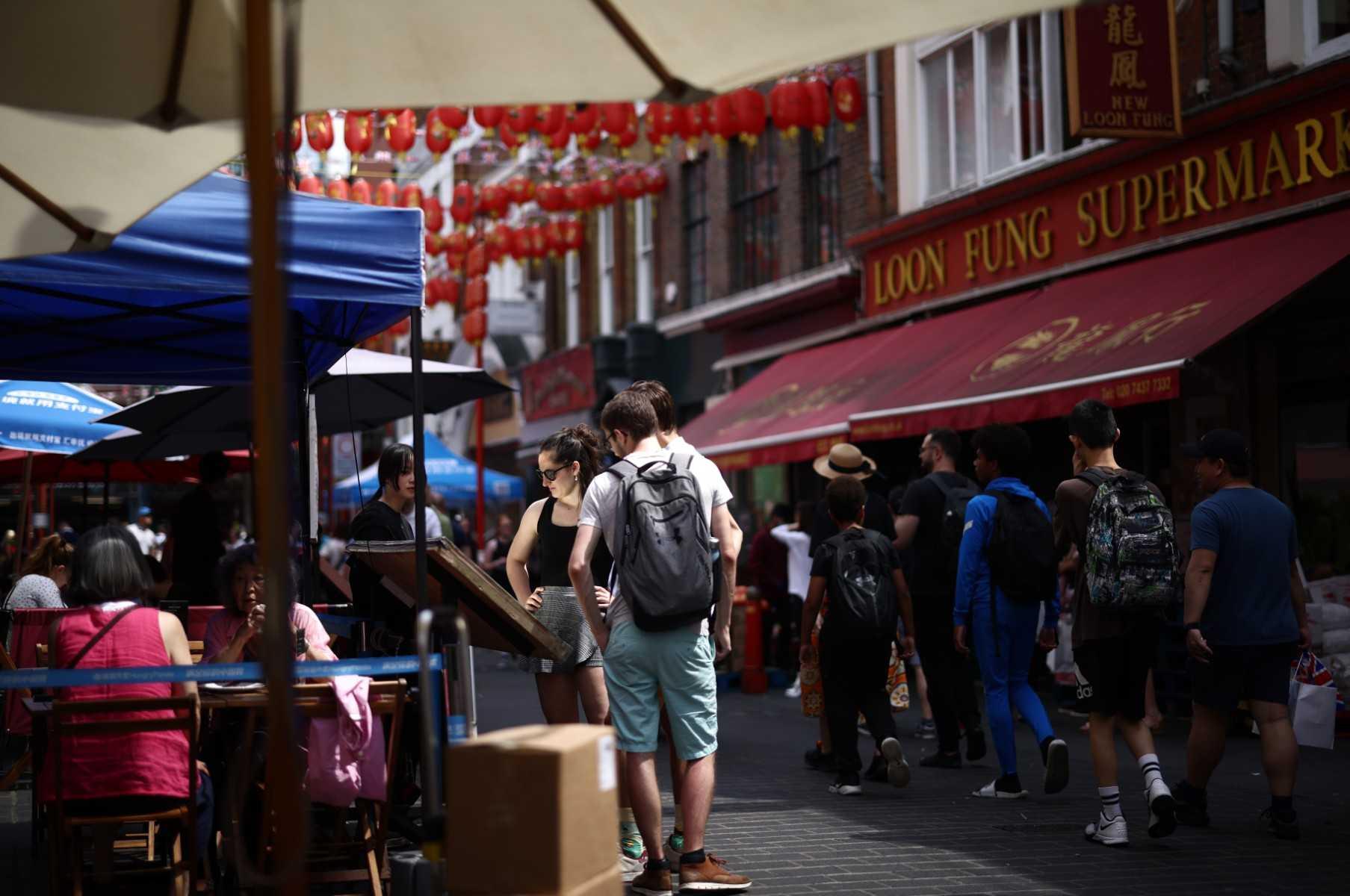 Members of the public read the menu outside a restaurant in the Chinatown area of Soho in London on June 18. Photo: AFP 