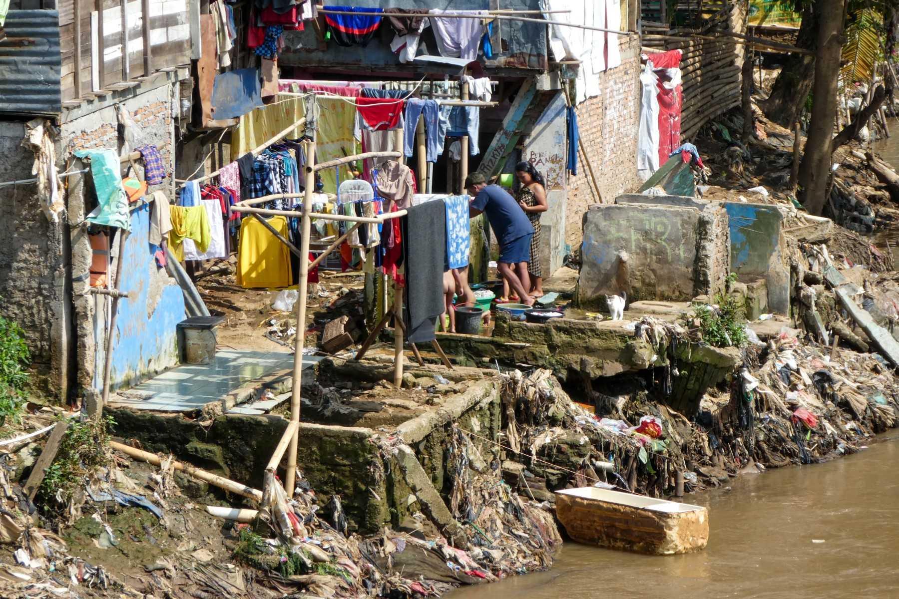 Residents use a river bank for bathing and washing laundry in Jakarta on April 22, 2020. Photo: AFP