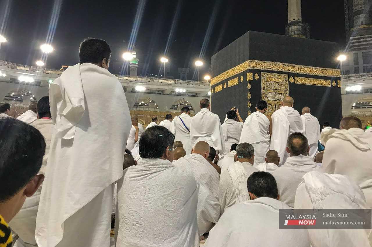 Pilgrims wait to perform their prayers in front of the kaaba, the cubic building at the Grand Mosque, in the city Mecca, Saudi Arabia.