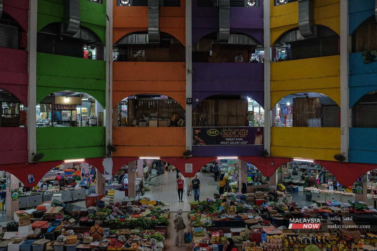 Customers and vendors mingle inside the brightly coloured building. 
