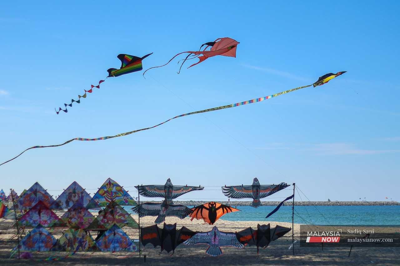 Brightly coloured kites fly against the blue sky at Pantai Cahaya Bulan.