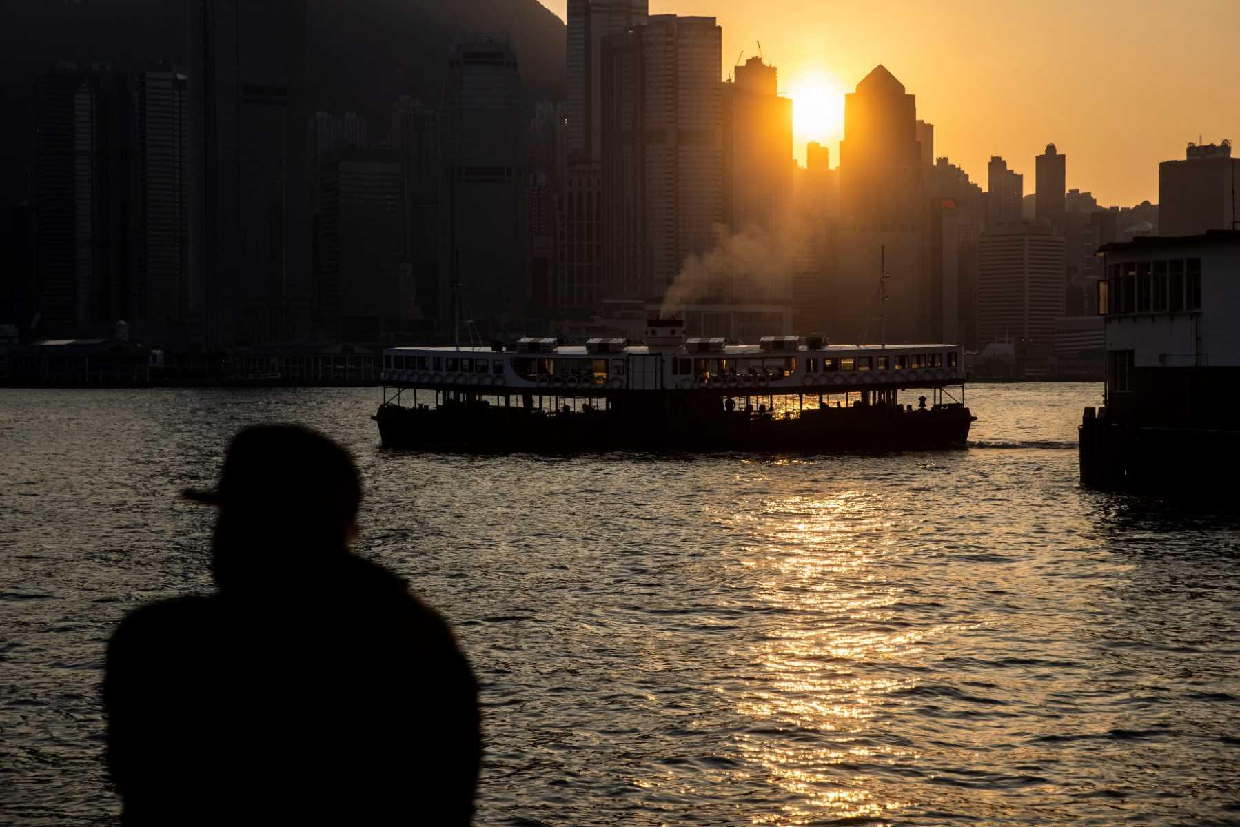 A man watches the sunset over Victoria Harbour in Hong Kong on Dec 30, 2022. Photo: AFP 