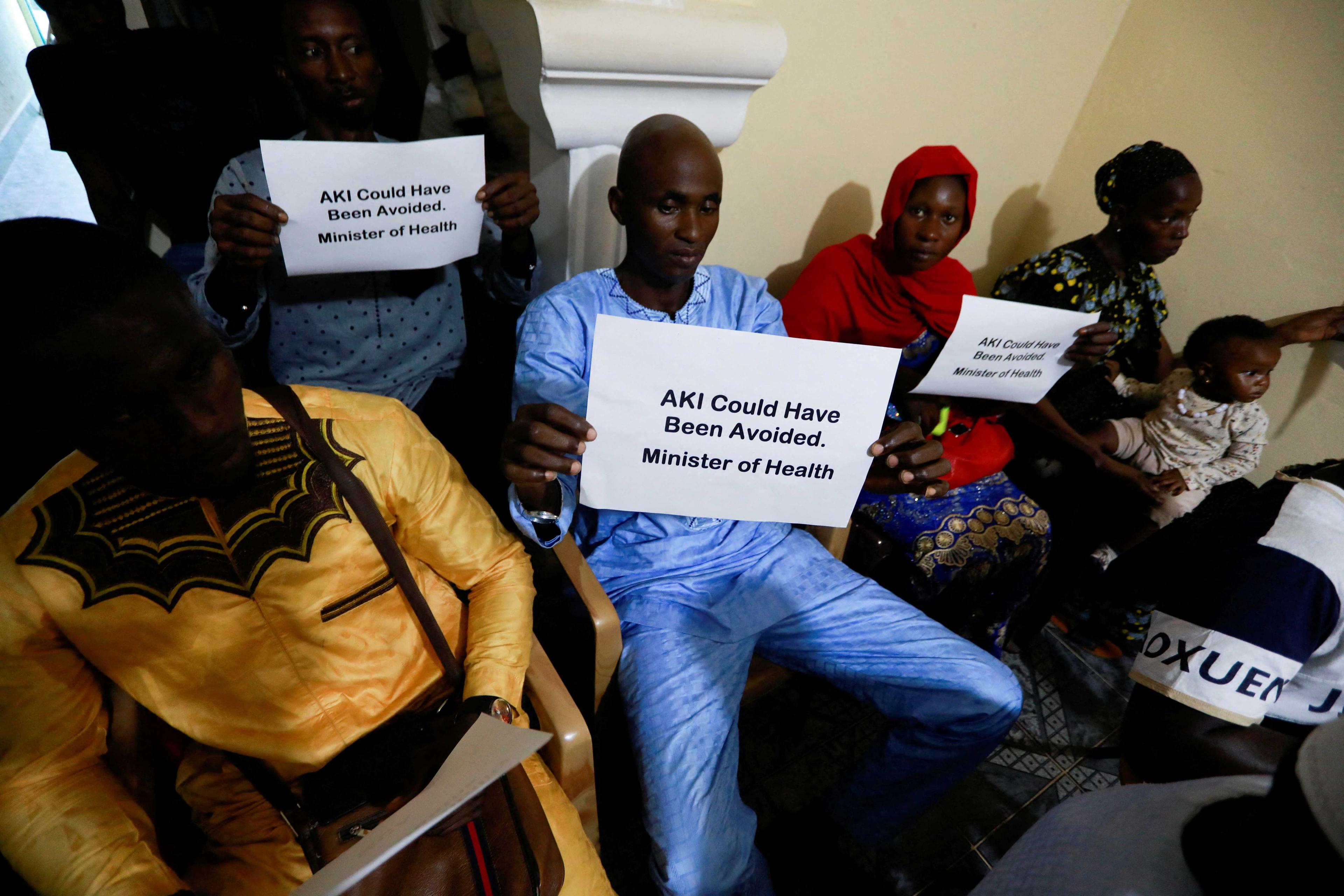Individuals hold up signs during a news conference, calling for justice for the deaths of children linked to contaminated cough syrups, in Serekunda, Gambia, Nov 4, 2022. Photo: Reuters