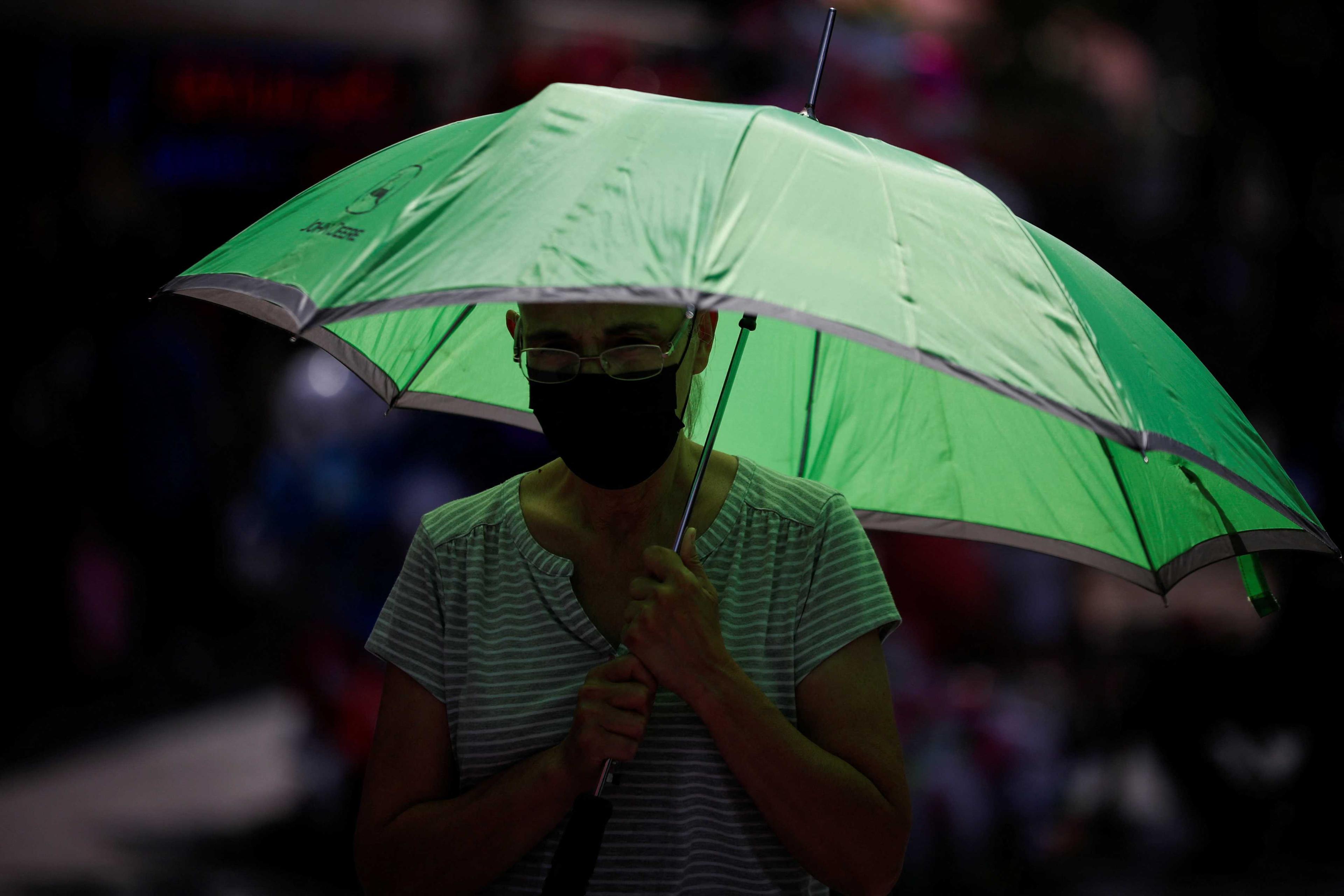A woman takes shelter with an umbrella as she walks on a sidewalk as temperatures rise during an unusual heat wave, in Monterrey, Mexico June 14. Photo: Reuters
