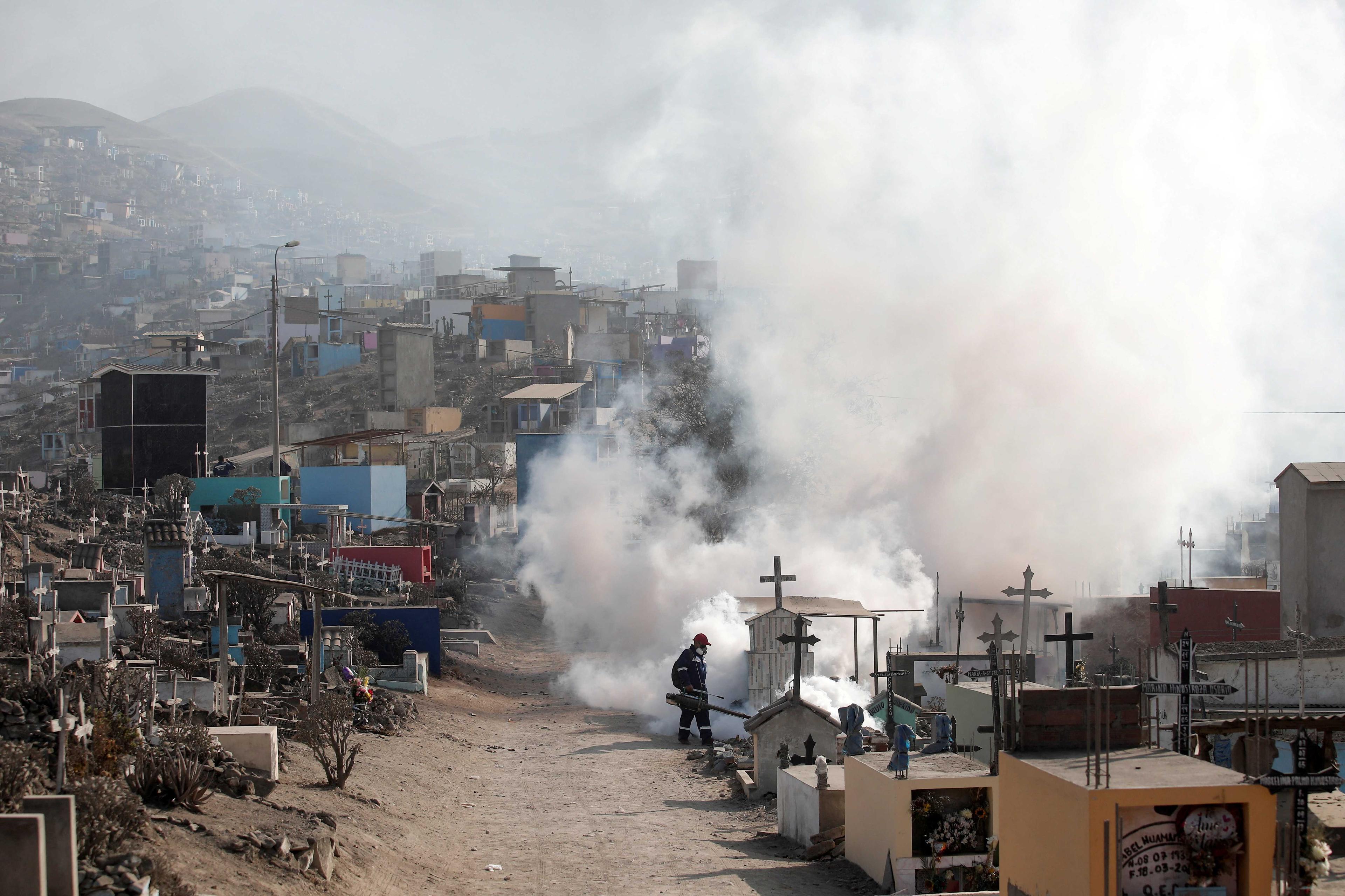 A health worker sprays fumigation vapour to stem the spread of dengue virus at the Nueva Esperanza cemetery in Lima, Peru, June 1, 2022. Photo: Reuters