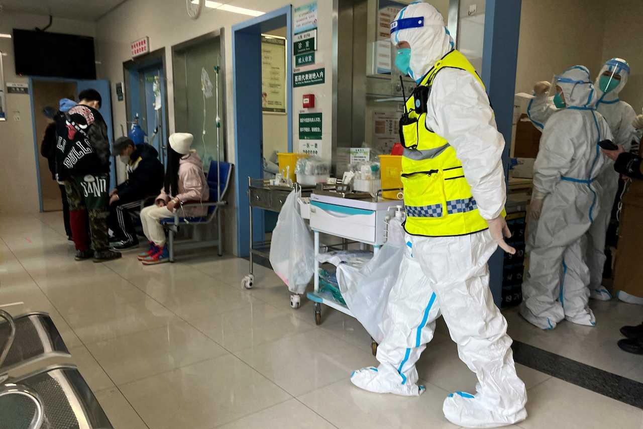 A security personnel in a protective suit keeps watch as medical workers attend to patients at the fever department of Tongji Hospital, a major facility for Covid-19 patients, in Wuhan, Hubei province, Jan 1. Photo: Reuters