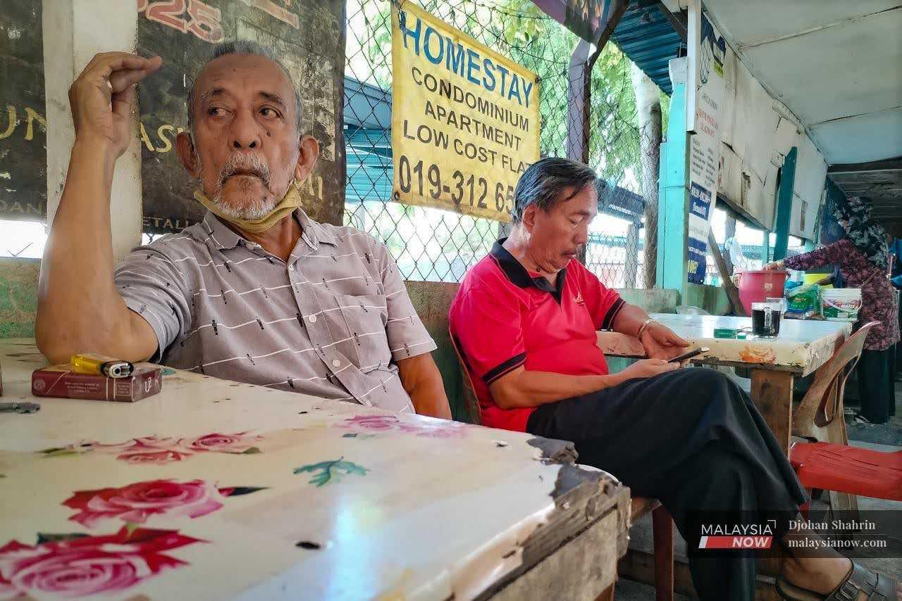 Dua penduduk Kampung Medan bersantai di sebuah kedai kopi berhampiran rumah mereka.