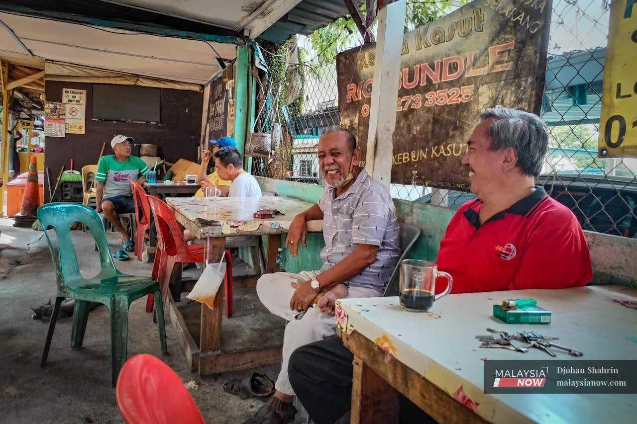 Kampung Medan residents laugh during a conversation at a neighbourhood coffee shop in Selangor. 
