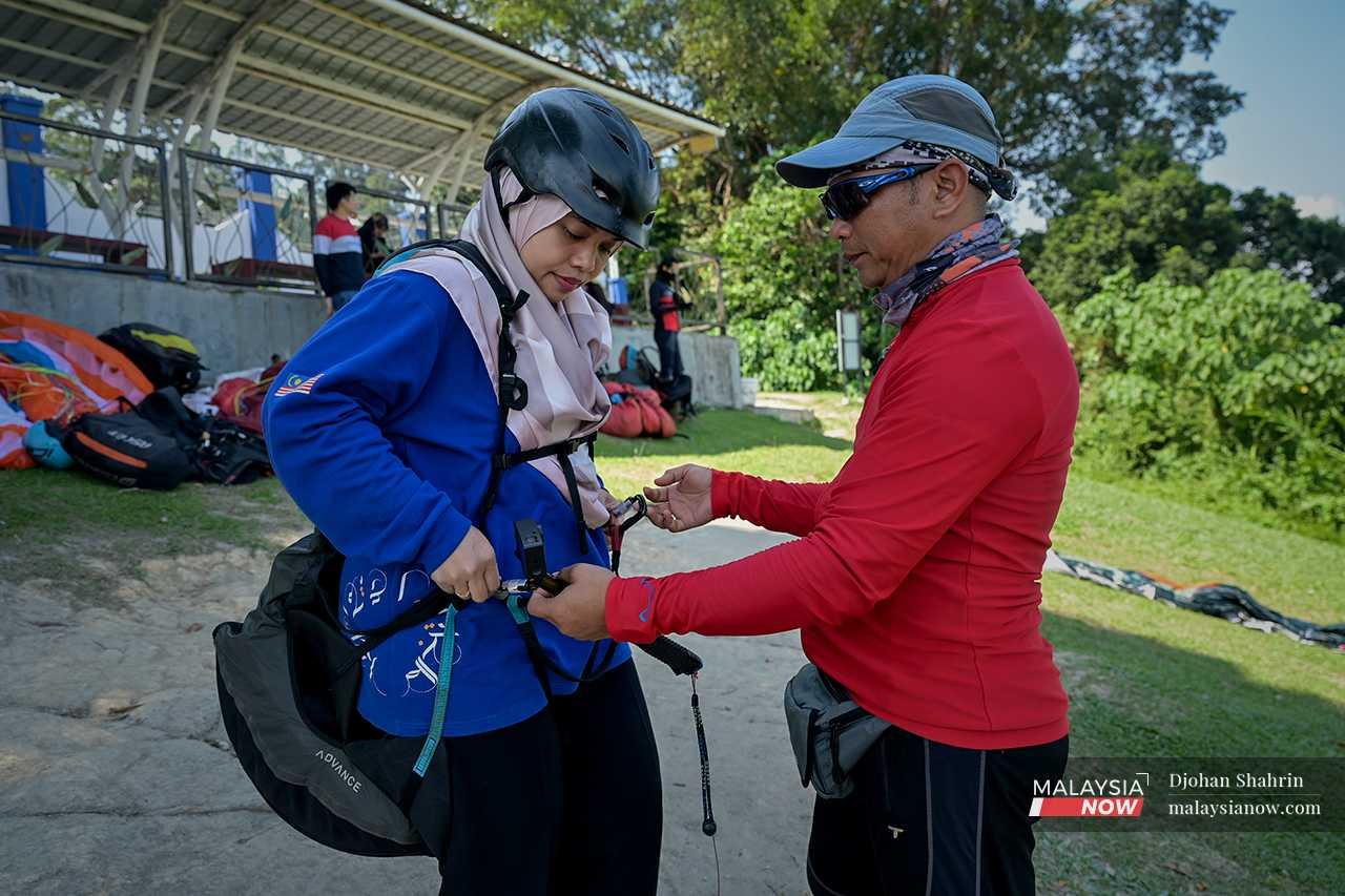 Ikhwan checks a woman's safety harness as part of the SOPs before the activity begins. 