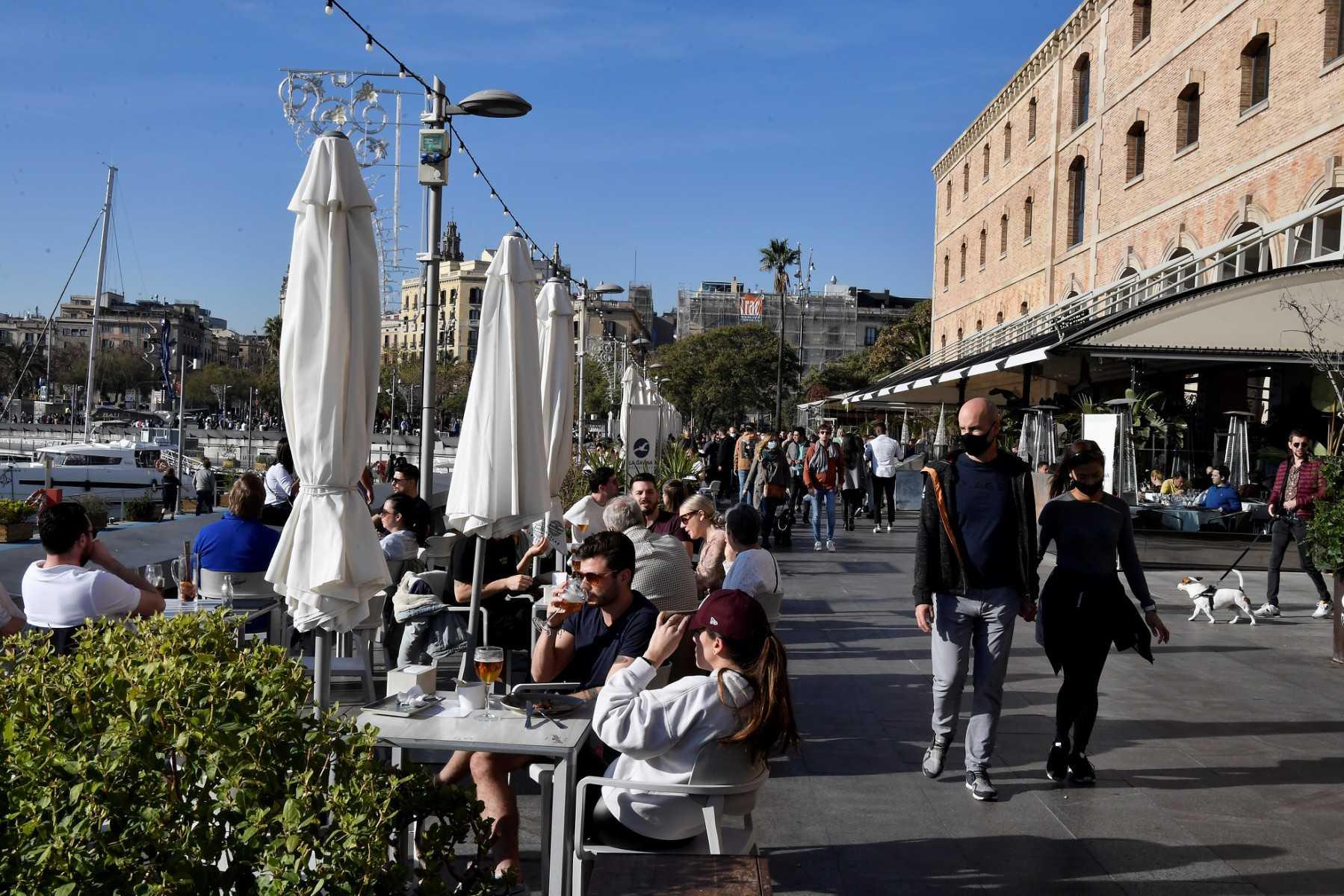 People walk on the promenade at Barceloneta neighborhood in Barcelona on Dec 31, 2021. Photo: AFP