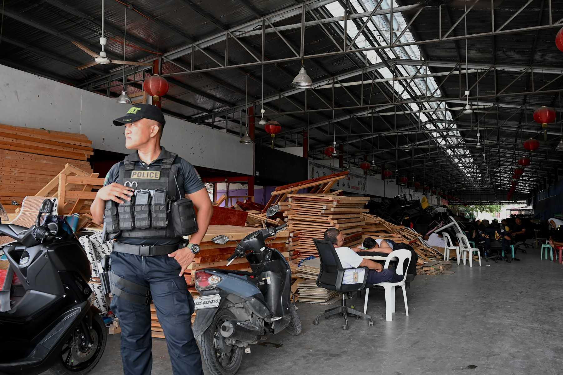 Seorang anggota polis berkawal di dalam kawasan serbuan di sebuah bangunan di Metro Manila pada 27 Jun. Gambar: AFP