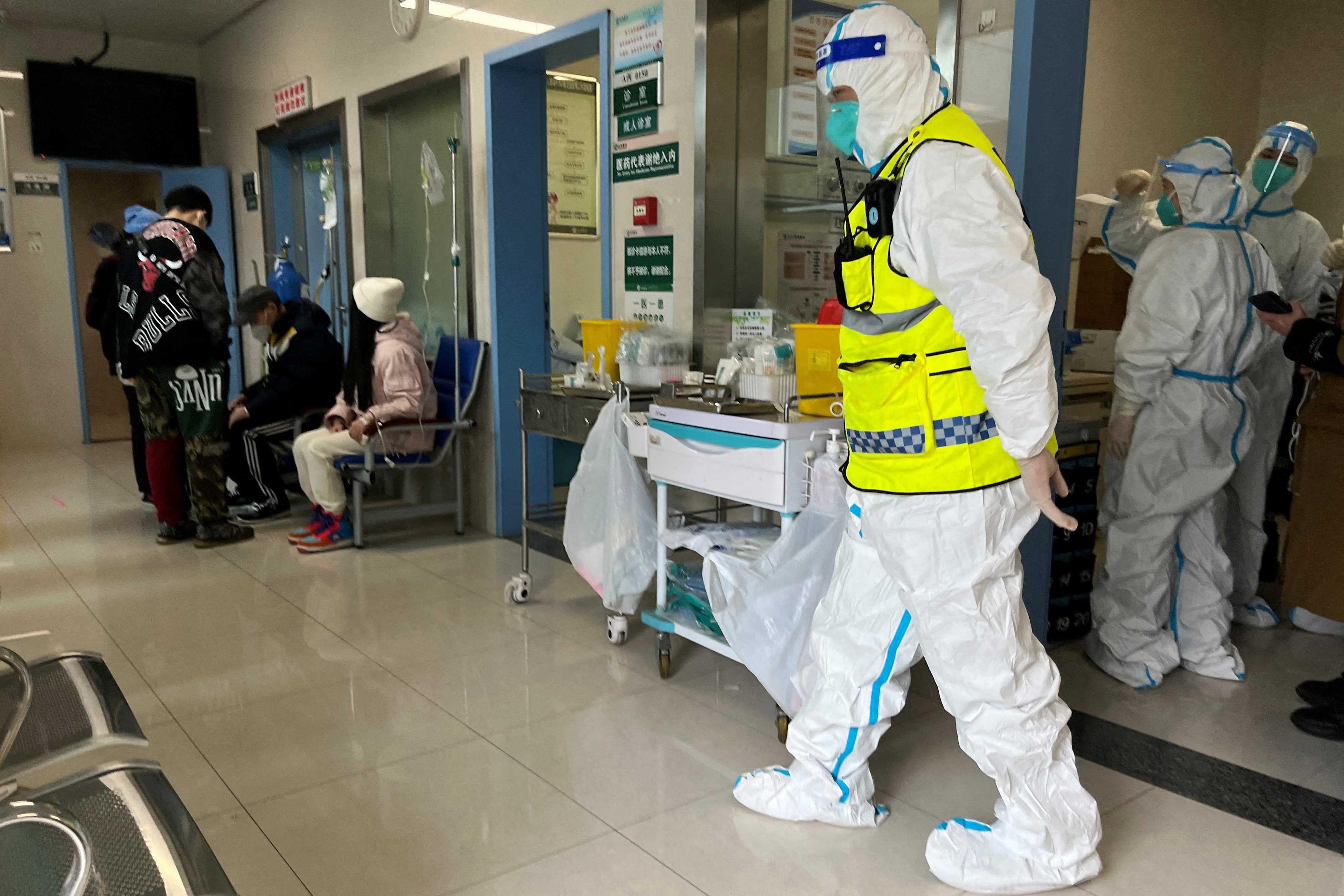 A security personnel in a protective suit keeps watch as medical workers attend to patients at the fever department of Tongji Hospital, in Wuhan, Hubei province, China Jan 1. Photo: Reuters