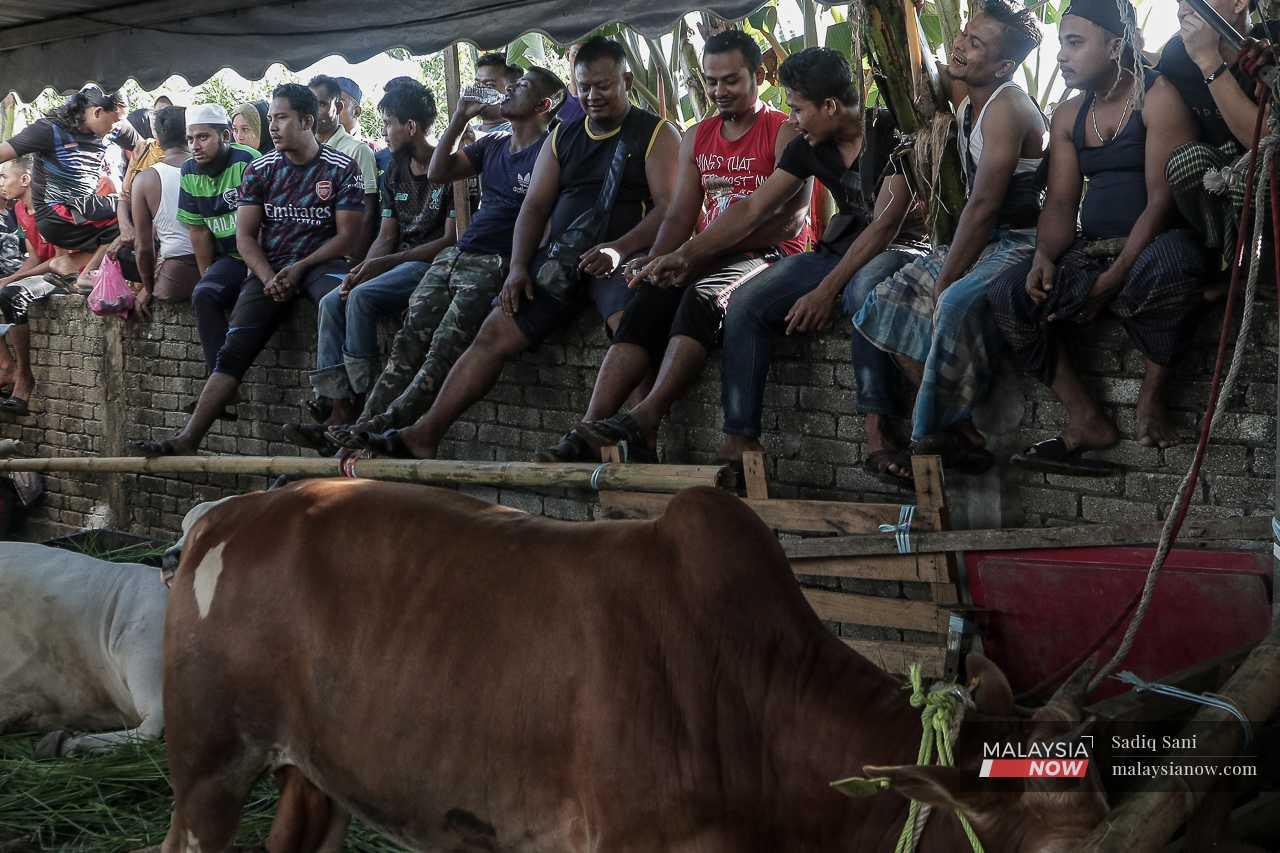 Sementara itu, lelaki Rohingya duduk di atas tembok rendah sambil menunggu majlis bermula. 