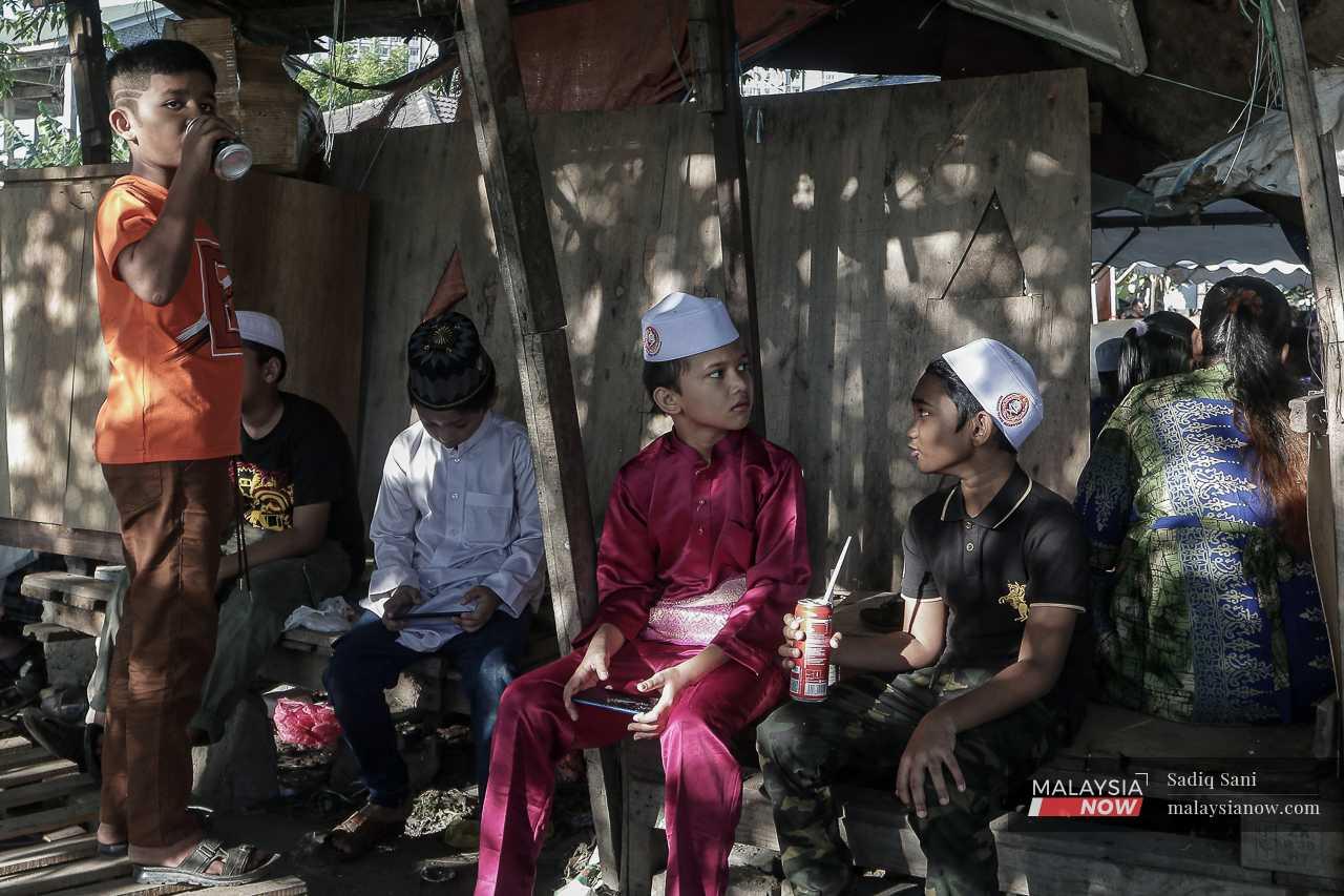 A Rohingya child wears a traditional baju Melayu as he and his friends wait for the ceremony of slaughter to begin. 