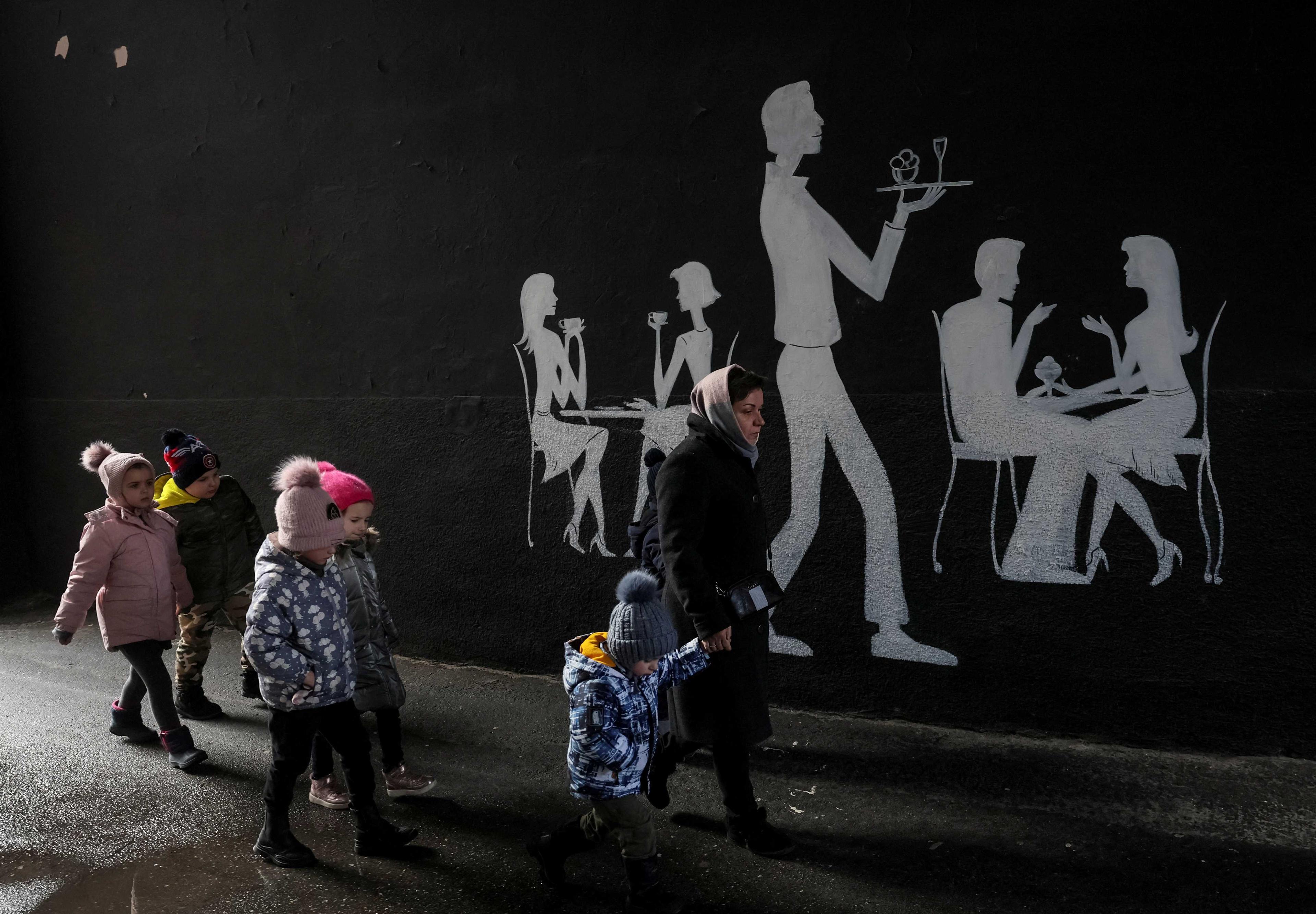 A kindergarten employee leads children to a bomb shelter during an air raid, amid Russia's attack on Ukraine, in central Kyiv, Ukraine March 7. Photo: Reuters