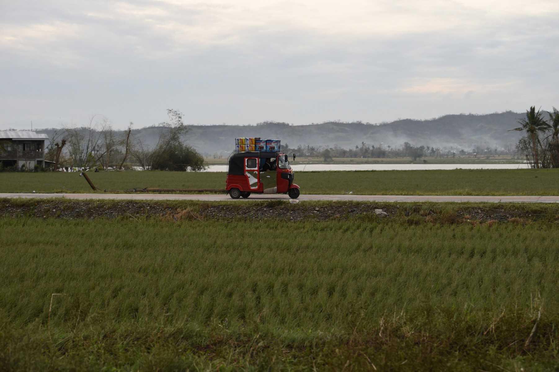 Basikal roda tiga yang sarat dengan penumpang berulang-alik melepasi ladang di Alcala, wilayah Cagayan pada 16 September 2018, ke bandar Baggao. Gambar: AFP