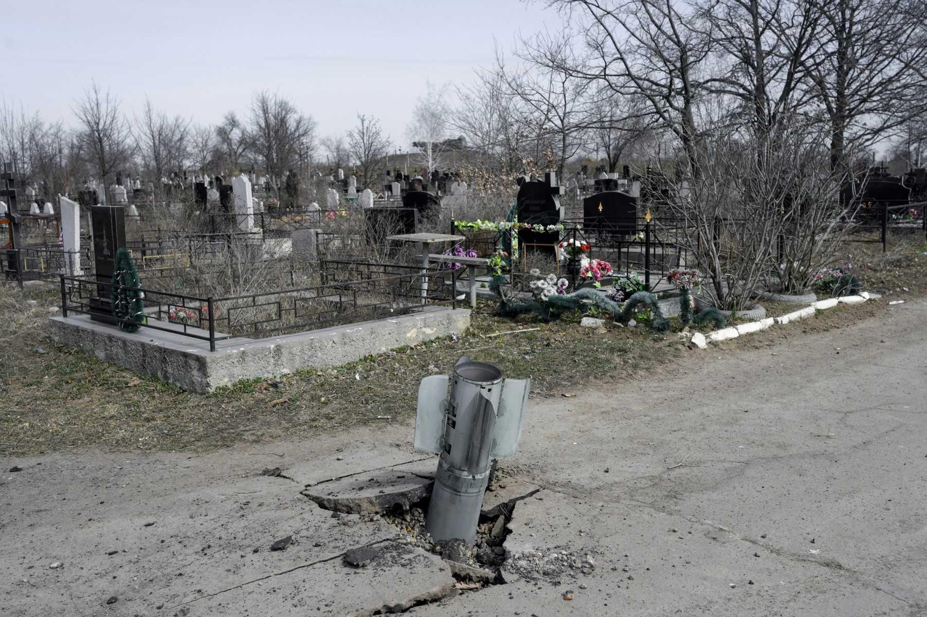 An unexploded tail section of a 220mm rocket which appear to contained cluster bombs launched from a BM-27 Uragan multiple rocket launcher, is seen in the cemetery of Mykolaiv, southern Ukraine, on March 21, 2022. Photo: AFP