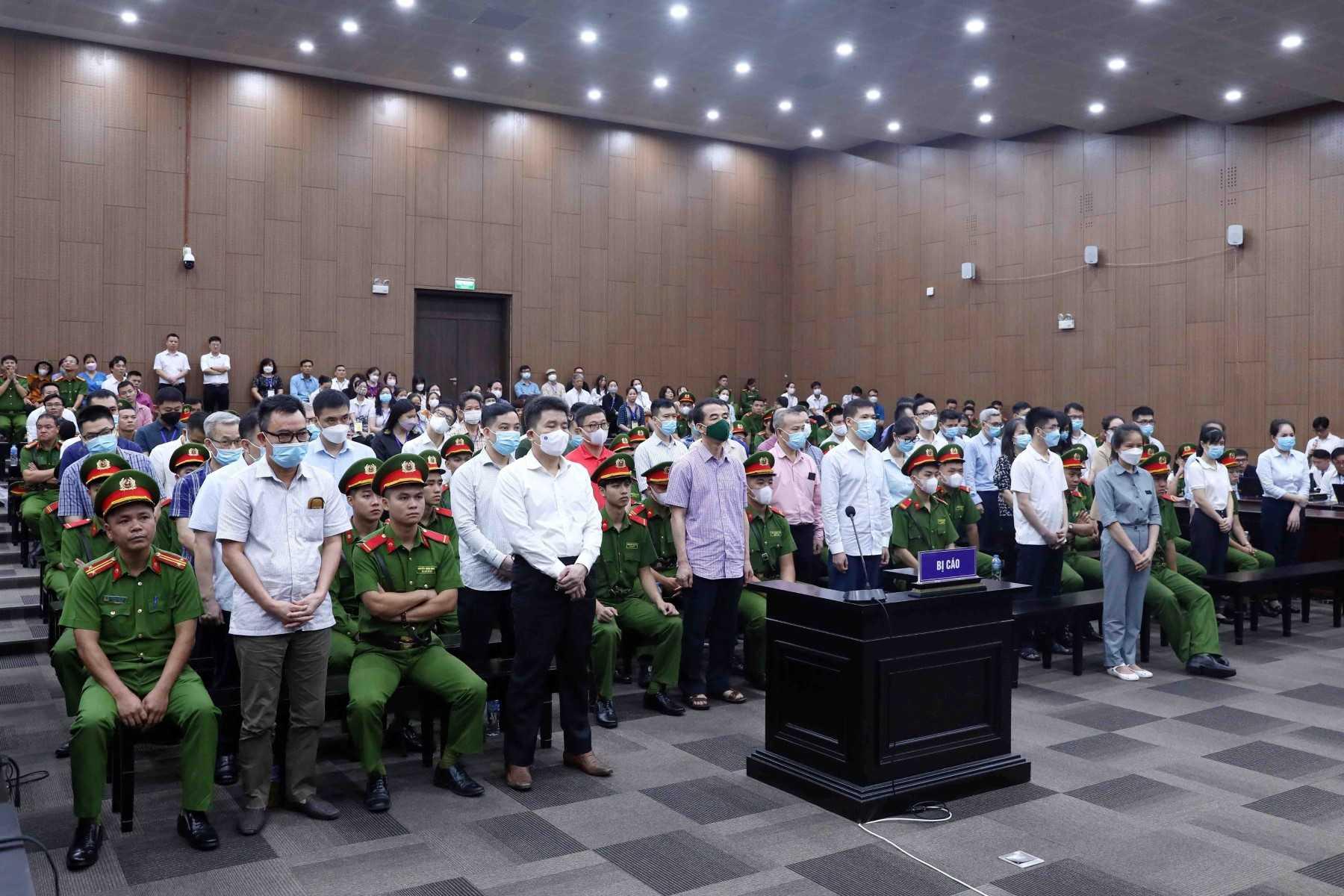 This picture taken and released by the Vietnam News Agency on July 11, shows defendants (front row standing) in a courtroom for the repatriation flight trial in Hanoi. Photo: AFP