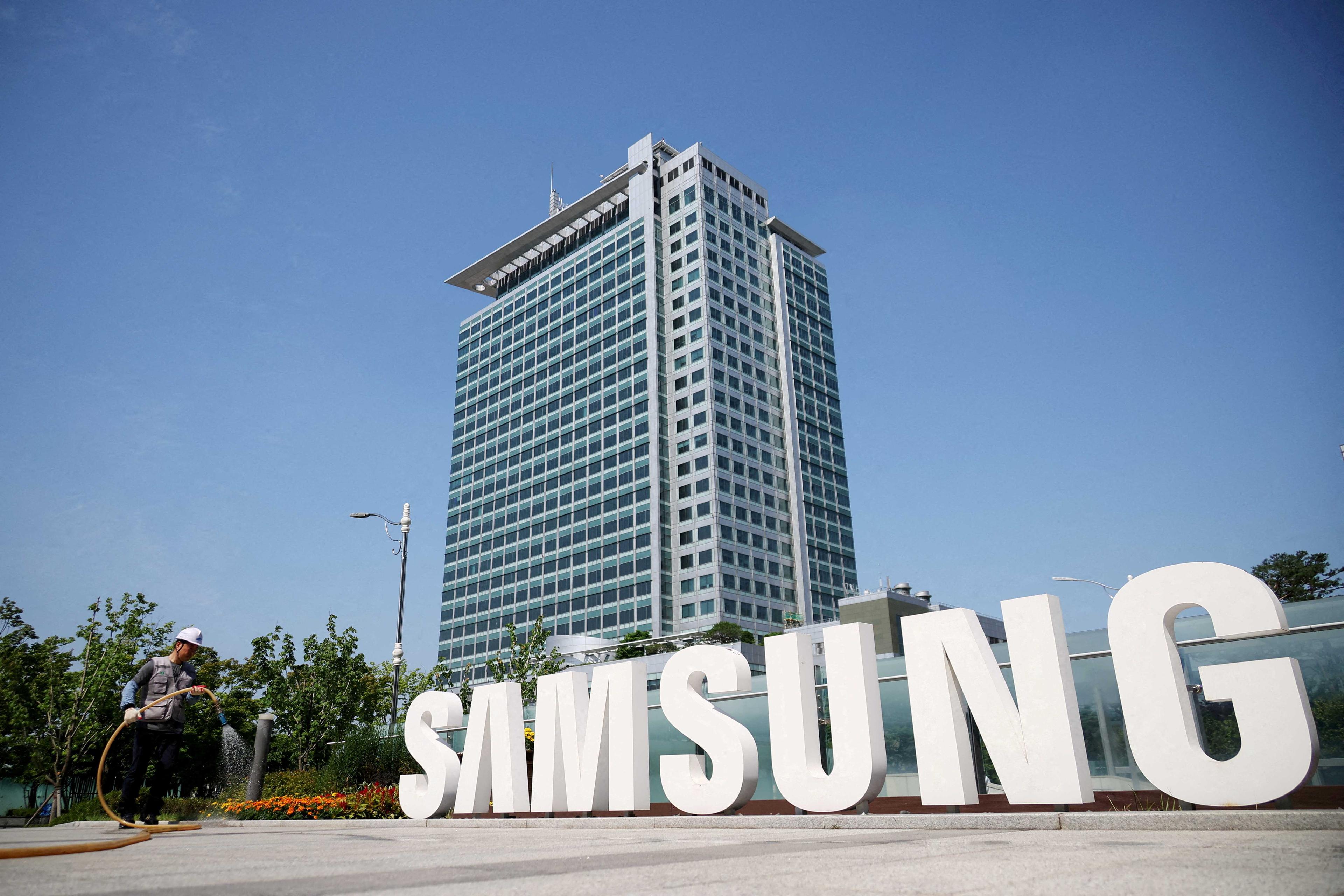 A worker waters a flower bed next to the logo of Samsung Electronics during a media tour at Samsung Electronics' headquarters in Suwon, South Korea, June 13. Photo: Reuters
