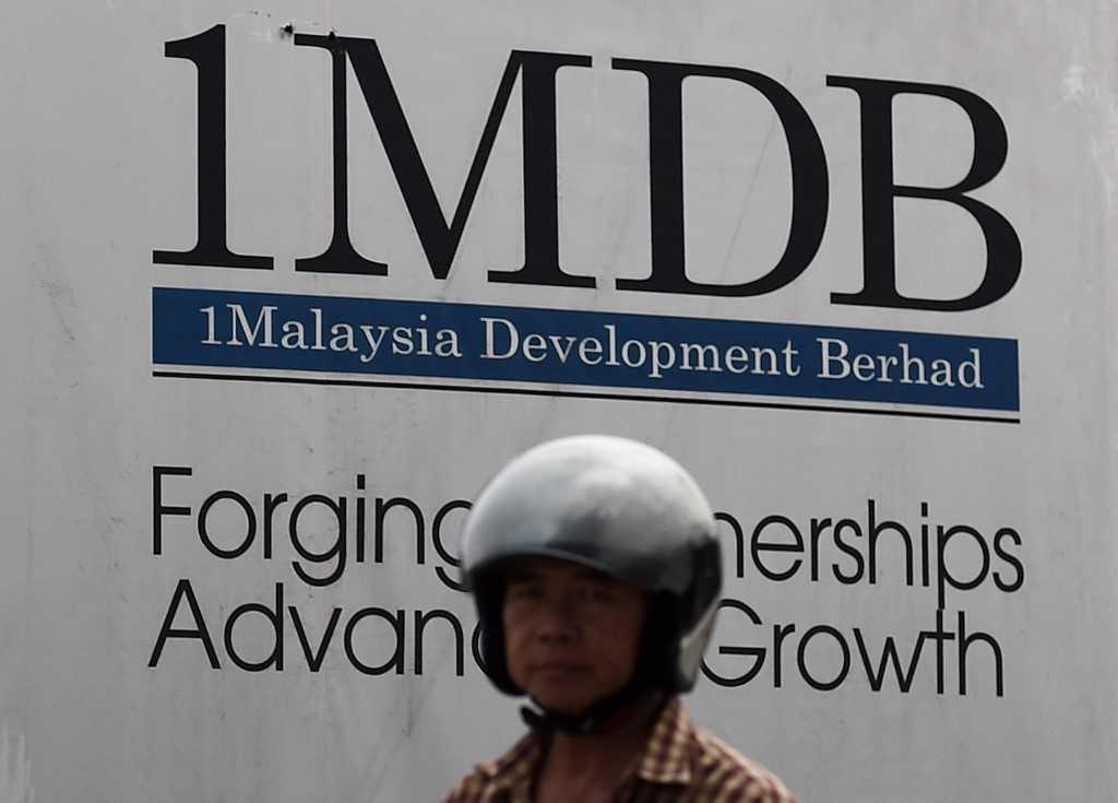 Seorang penunggang motosikal melepasi tapak pembinaan utama 1MDB, Tun Razak Exchange di Kuala Lumpur pada 8 Julai 2015. Gambar: AFP