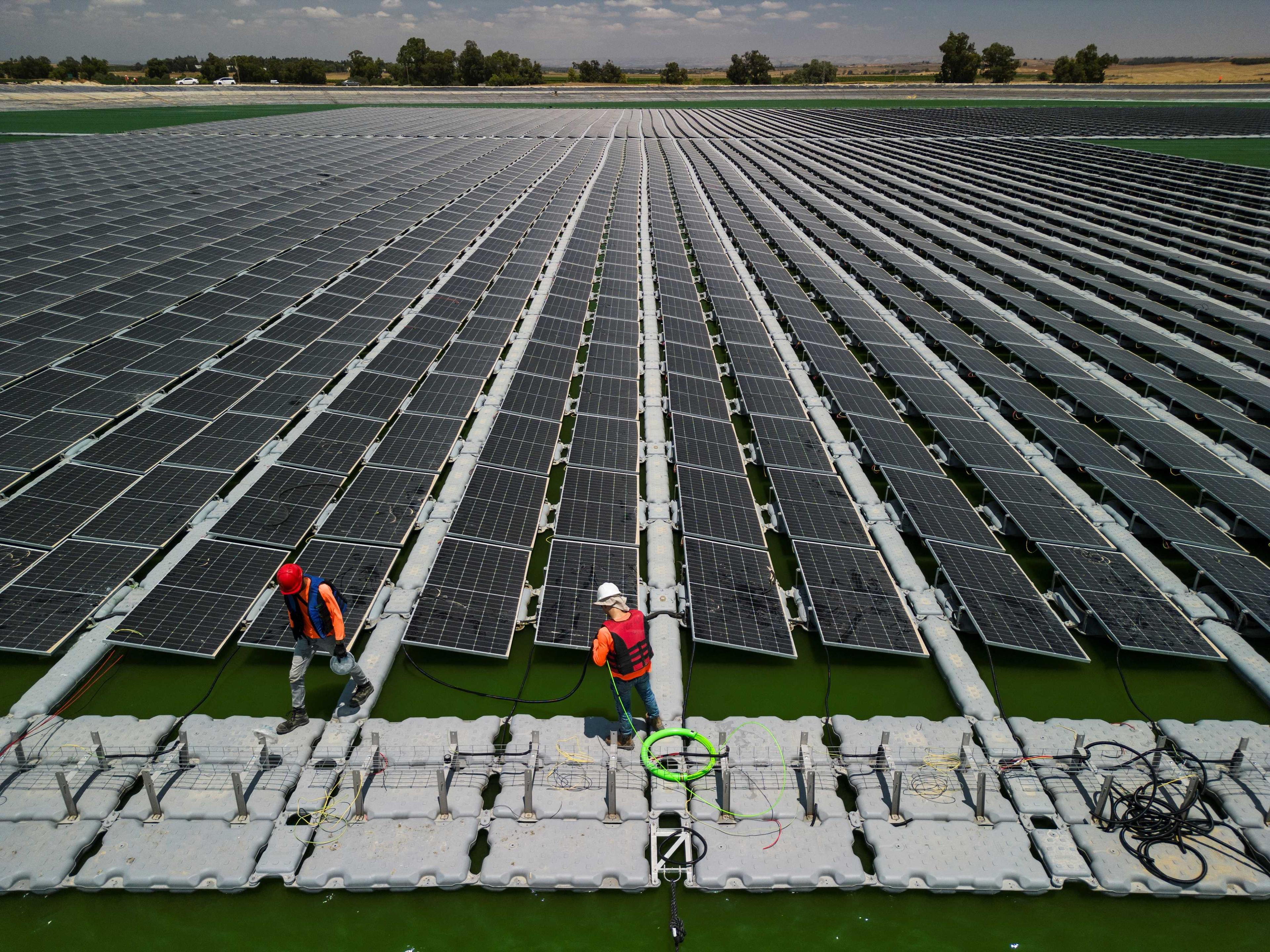 Pemandangan dari udara menunjukkan pekerja dari Nofar Energy memasang panel solar pada takungan air di luar Kibbutz Or HaNer, Israel 19 Jun. Gambar: Reuters