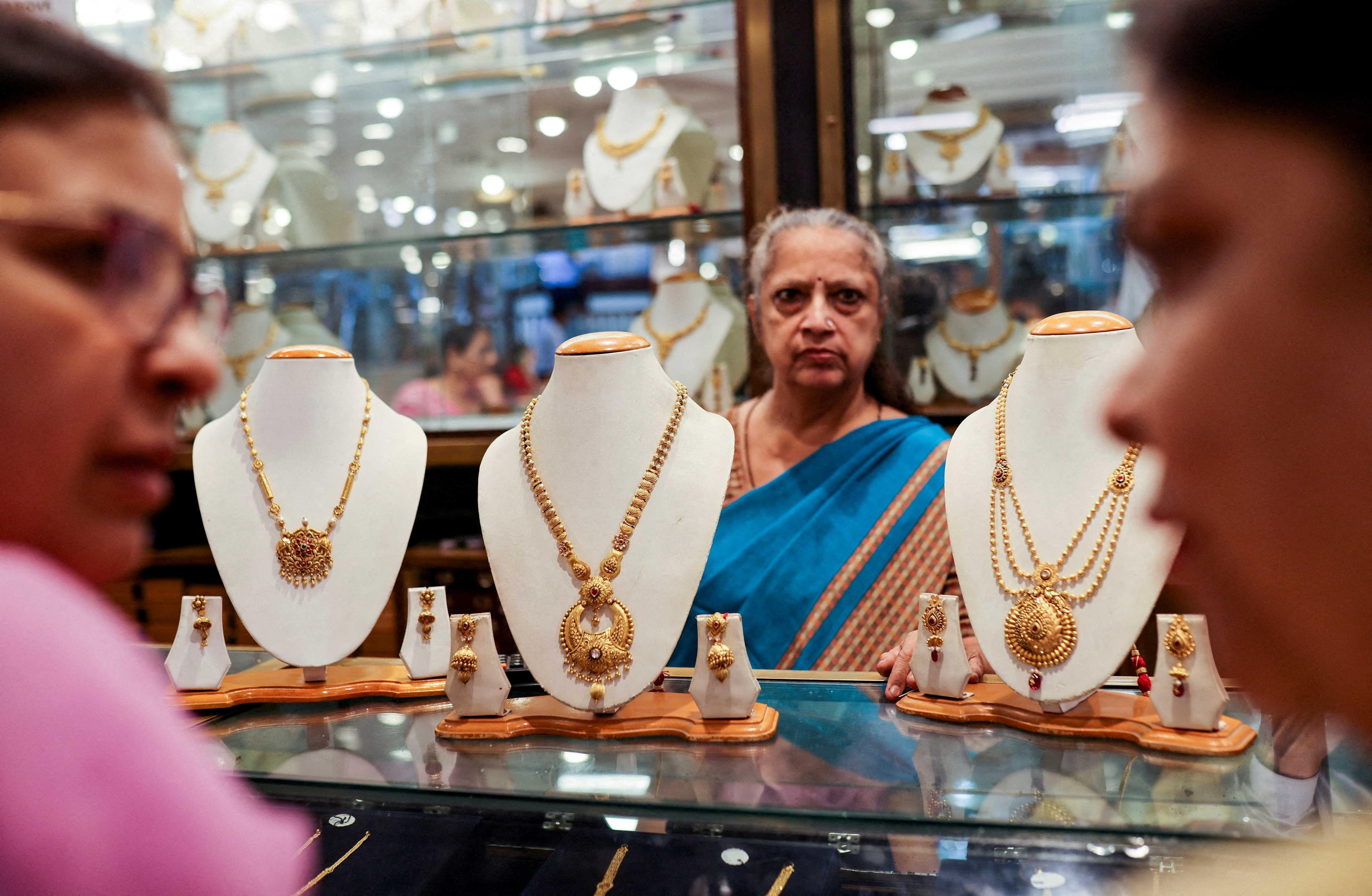 Customers check gold ornaments at a jewellery shop in the old quarters of Delhi, India, May 24. Photo: Reuters