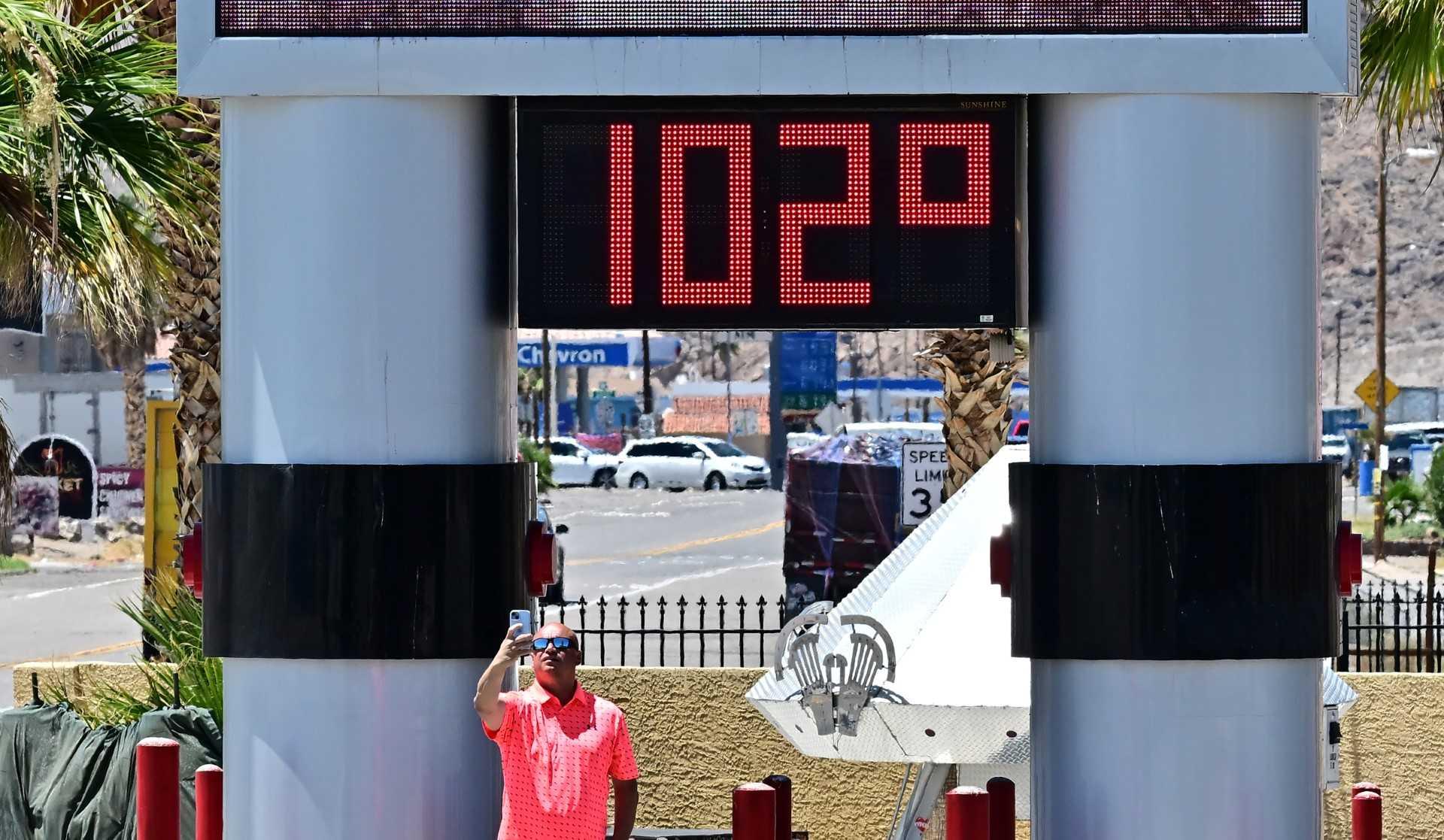 A man takes a selfie beside a thermometer showing the temperature in Baker, California, on July 11. Photo: AFP