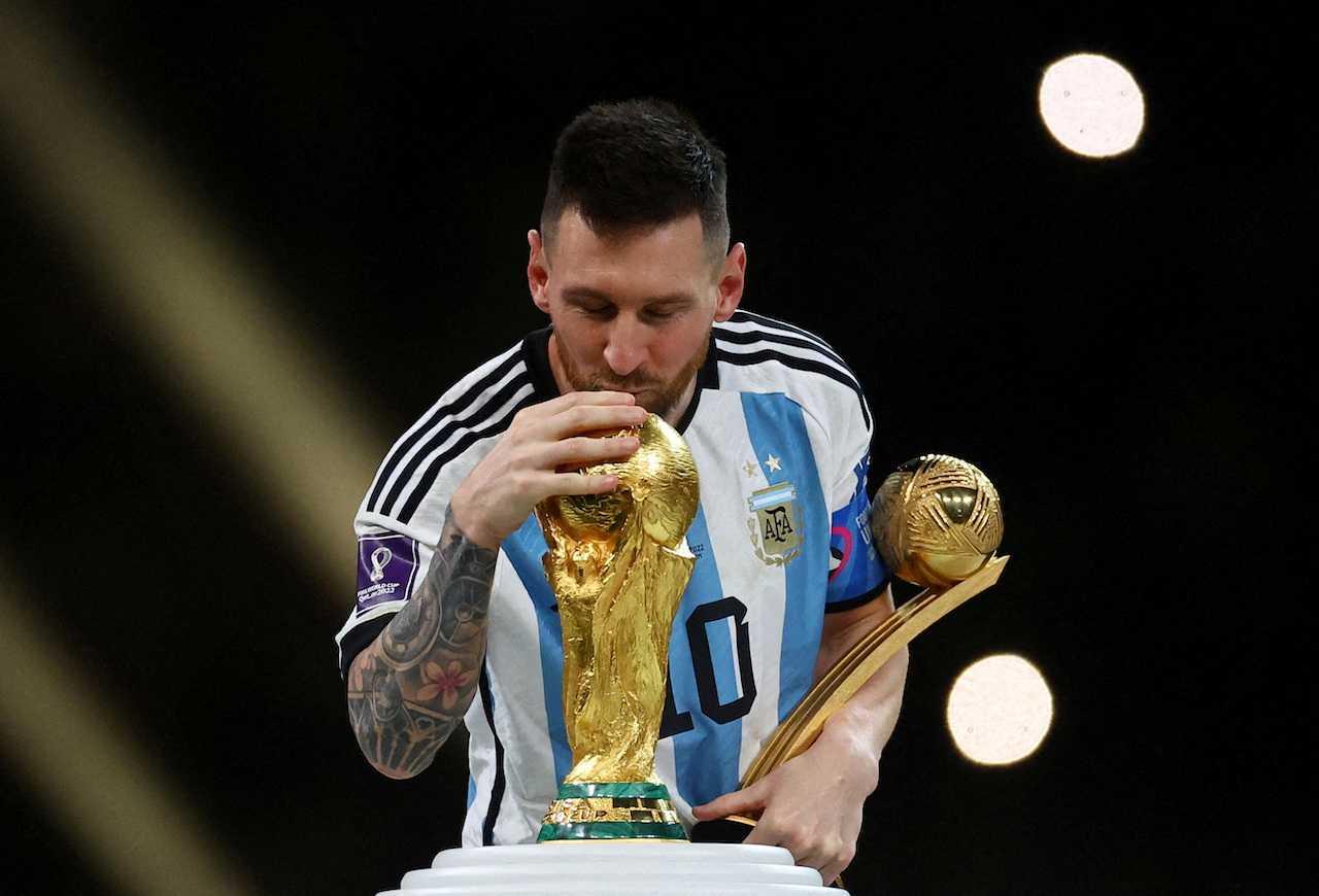 Argentina's Lionel Messi kisses the World Cup trophy after receiving the Golden Ball award as he celebrates after winning the World Cup, at Lusail Stadium in Lusail, Qatar, Dec 18, 2022. Photo: Reuters