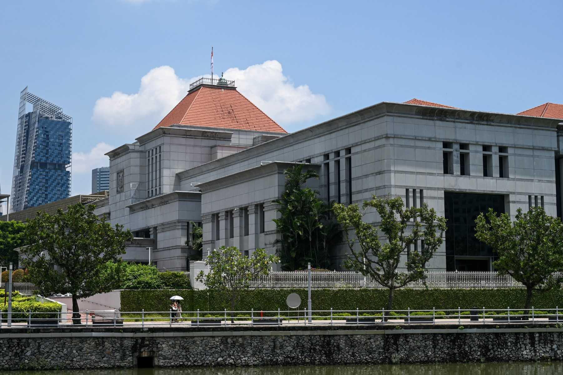 People walk along the side of the Parliament building in Singapore on Oct 20, 2022. Photo: AFP