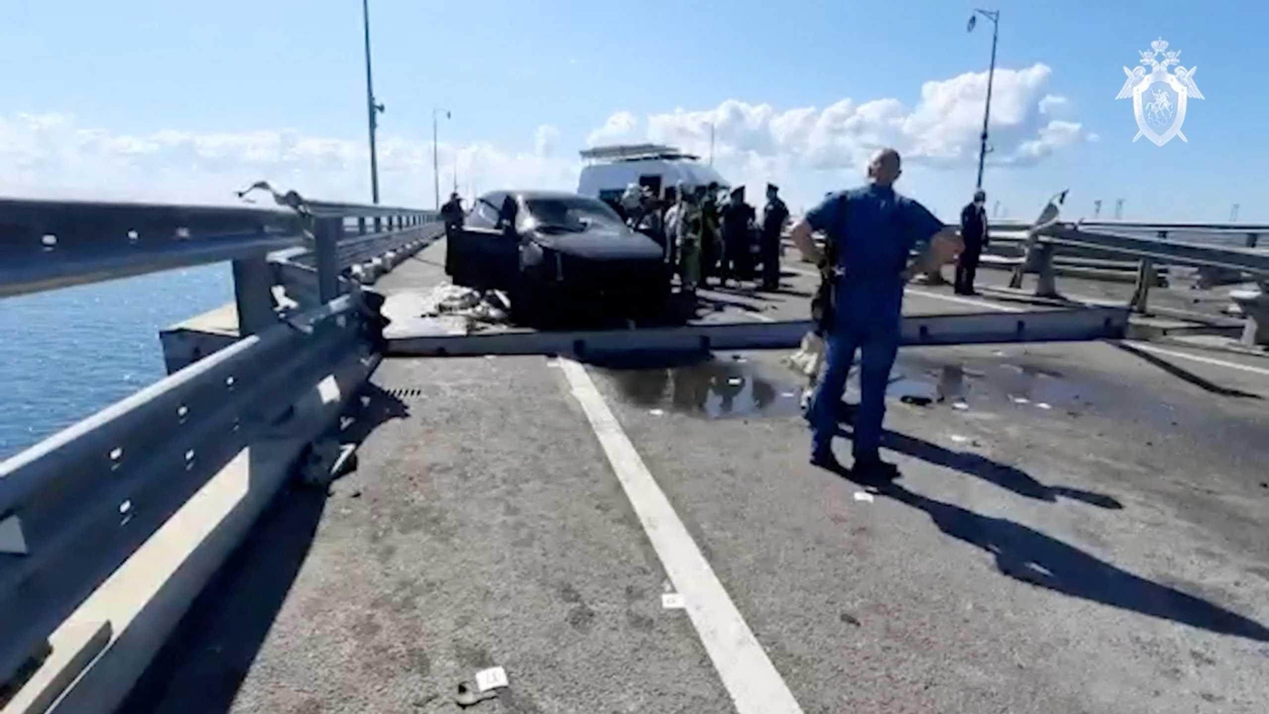 Russian investigators and emergency services' members gather near a destroyed car at the accident scene on the damaged section of a road following an alleged attack on the Crimea Bridge, in this still image taken from video released July 17. Photo: Reuters