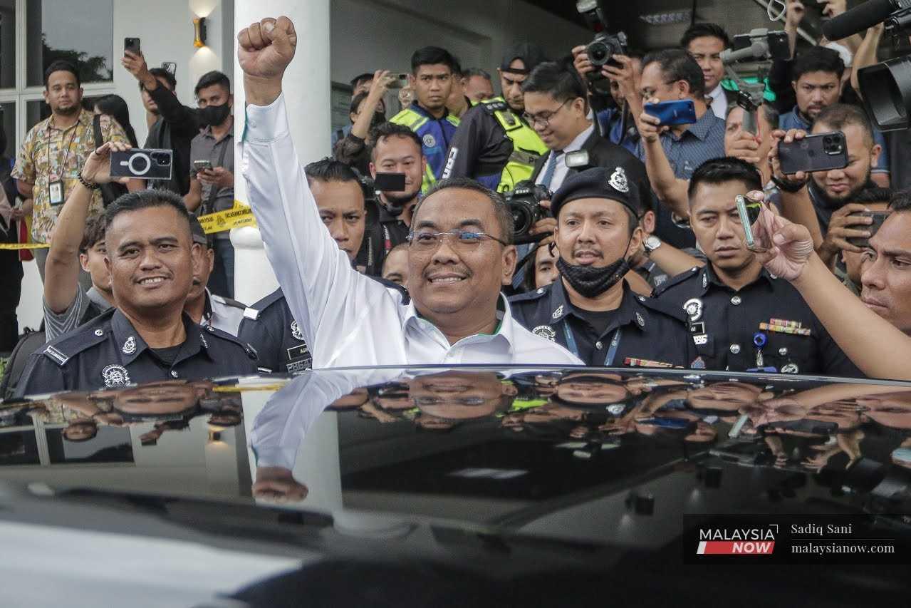 Kedah Menteri Besar Muhammad Sanusi Md Nor raises his fist as he leaves the Selayang Sessions Court where he was charged with sedition, July 18.