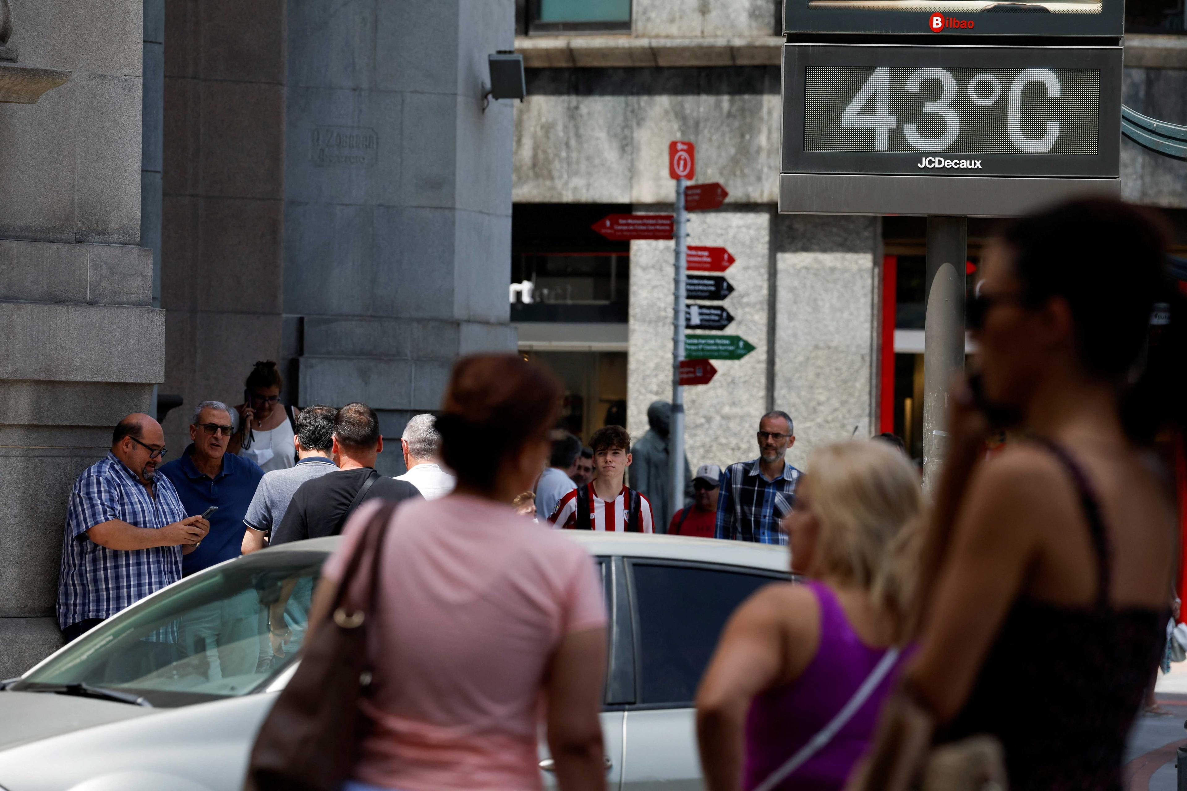 People walk near a sign indicating 43 degrees Celsius as near record temperatures continue to affect the country, in Bilbao, Spain June 17. Photo: Reuters