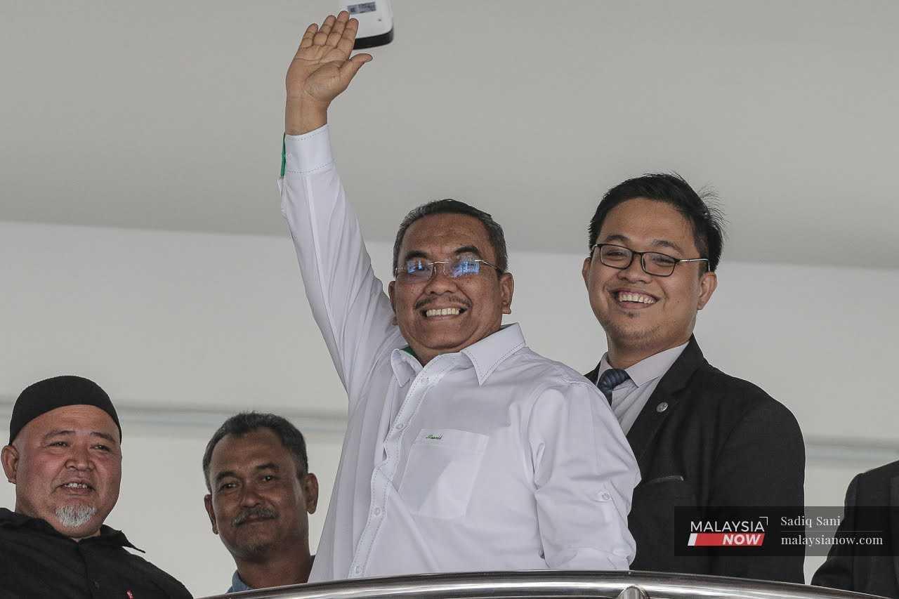 Menteri Besar Kedah Muhammad Sanusi Md Nor melambai di Mahkamah Sesyen Selayang di mana dia didakwa menghasut, 18 Julai.
