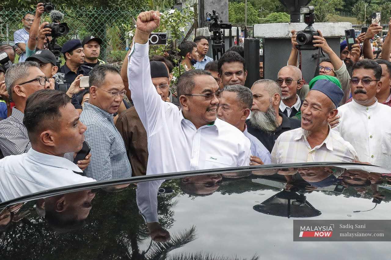 Menteri Besar Kedah Muhammad Sanusi bersalaman dengan penyokongnya di luar Mahkamah Selayang pada 18 Julai selepas beliau didakwa menyentuh isu 3R kaum, agama dan raja dalam ceramah politiknya.