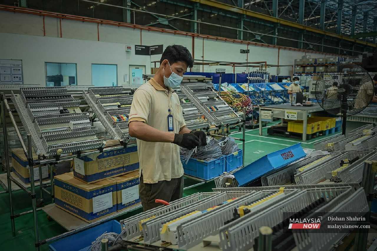Pekerja kilang elektronik melakukan kerja-kerja produksi di kawasan perindustrian Kota Damansara.