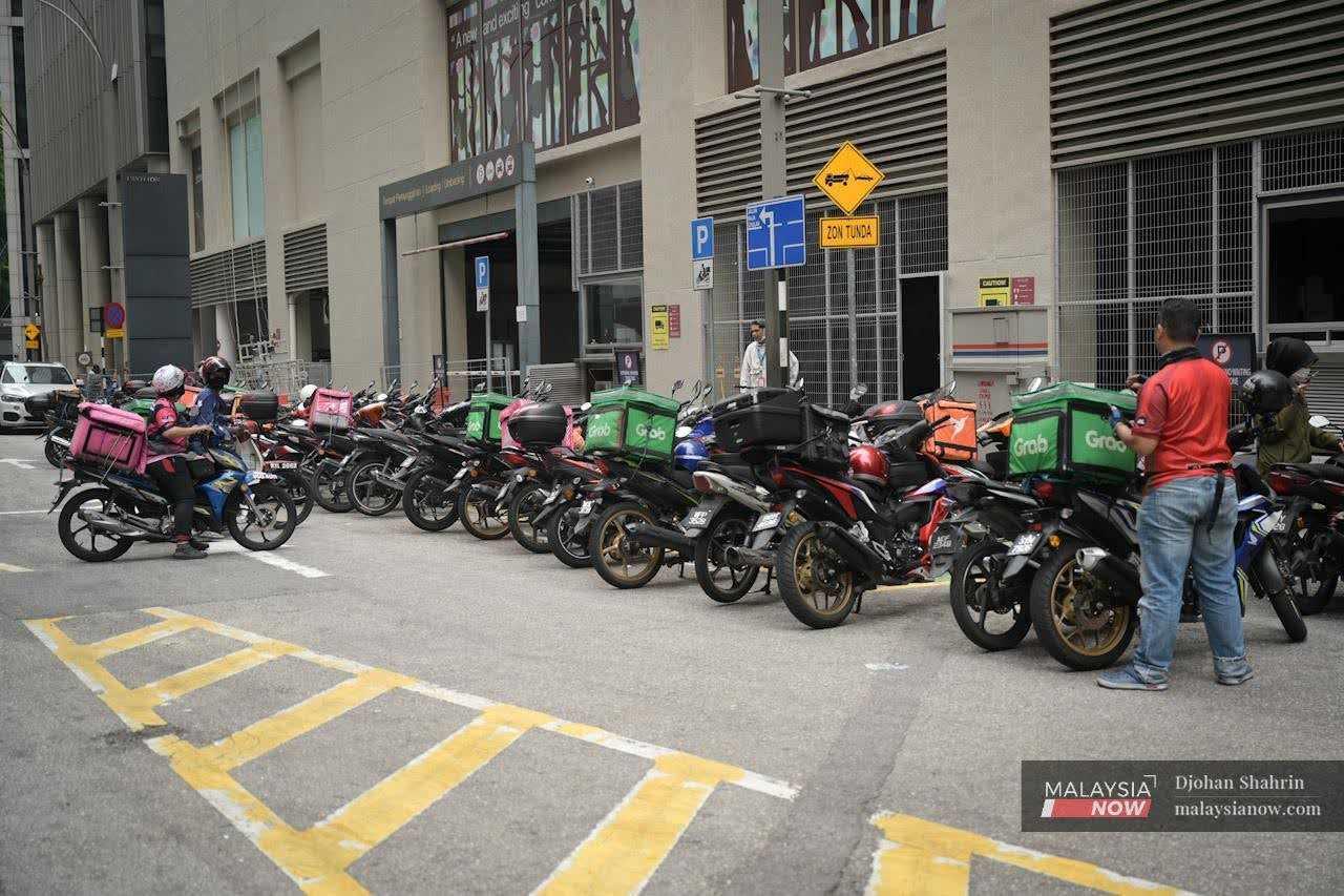 Food delivery riders wait for orders in Bukit Bintang, Kuala Lumpur. 
