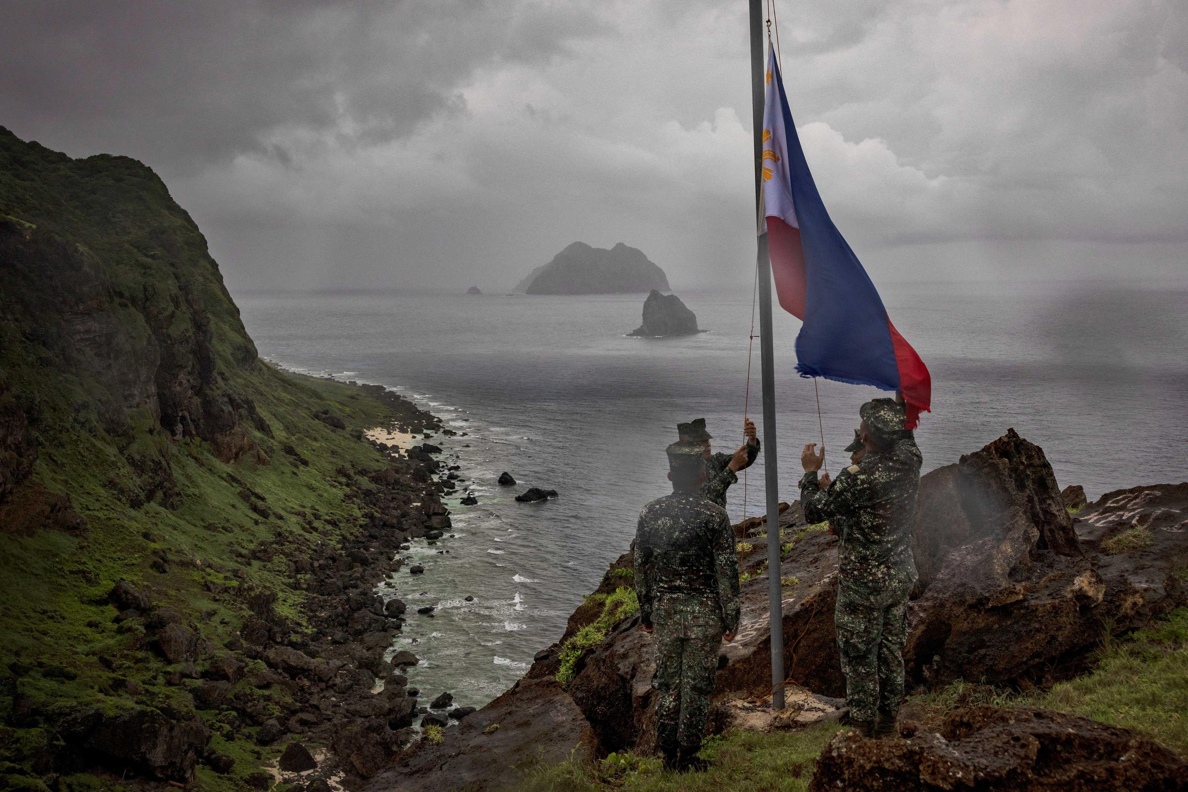 Filipino soldiers take part in a flag raising ceremony on Mavulis Island during a trip of the chief of staff of the Armed Forces of the Philippines, in Batanes, Philippines, June 29. Photo: Reuters